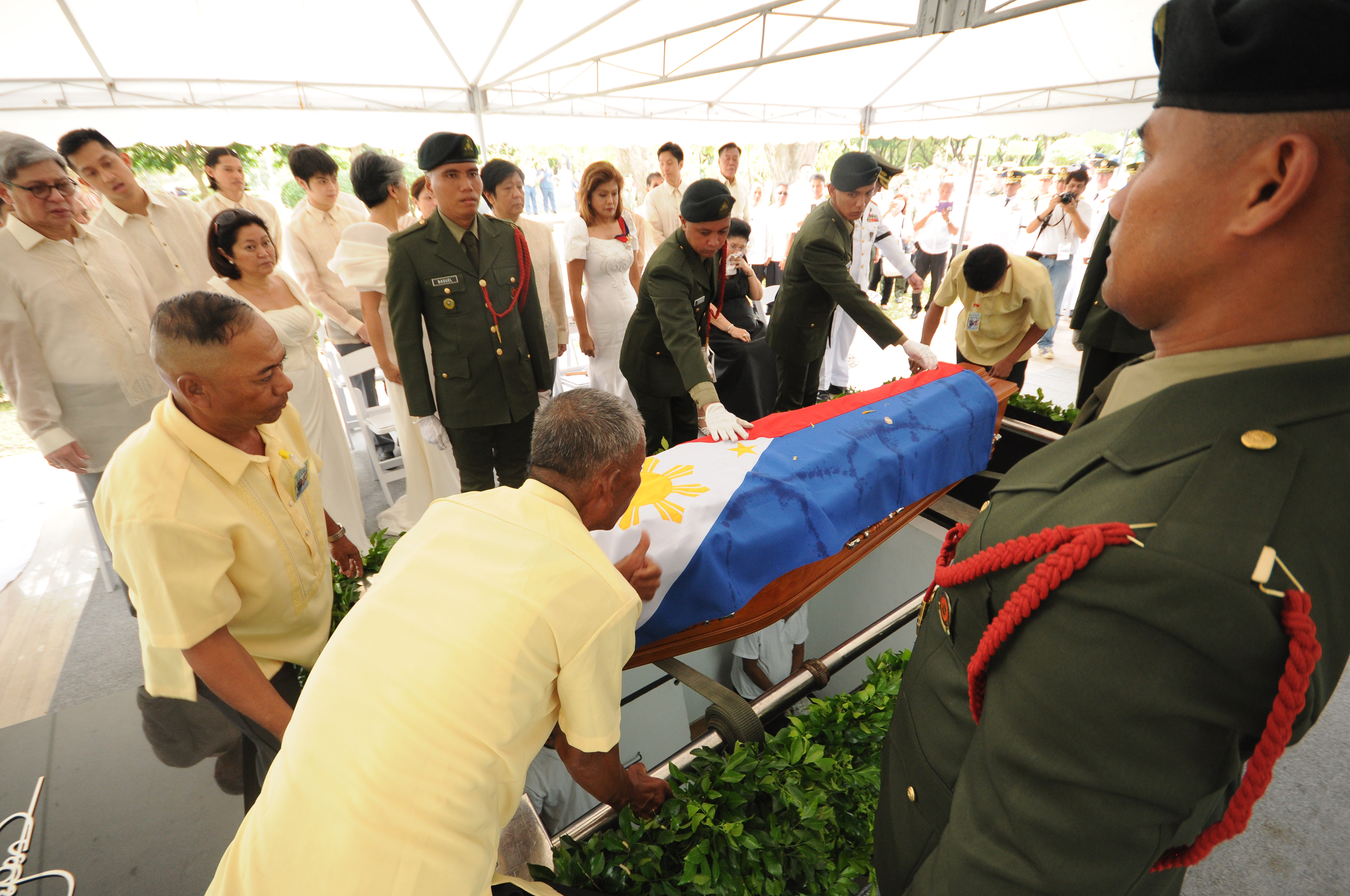 This photo taken on November 18, 20916 and released by the office of Governor Imee Marcos shows workers prepare to lower the coffin of the late dictator Ferdinand Marcos draped in national flag while members of the family (back) look on during the burial at the heroes' cemetery in Manila.   Ex-Philippine dictator Ferdinand Marcos was buried at the national heroes' cemetery in a secretive ceremony November 18, outraging opponents who said it whitewashed his brutal rule and tainted the famous 1986 "People Power" revolution that toppled him.   / AFP PHOTO / Office of Governor Imee Marcos / HO