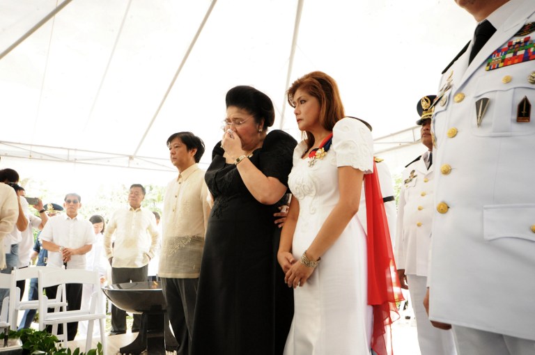 This handout photo taken on November 18, 2016 and released by the office of Governor Imee Marcos shows former first lady Imelda Marcos (in black) mourns with son Bongbong Marocs (L) and daughter Governor Imee Marcos during the burial of the late President Ferdinand Marcos at the heroes' cemetery in Manila. / AFP PHOTO / Office of Governor Imee Marcos / HO