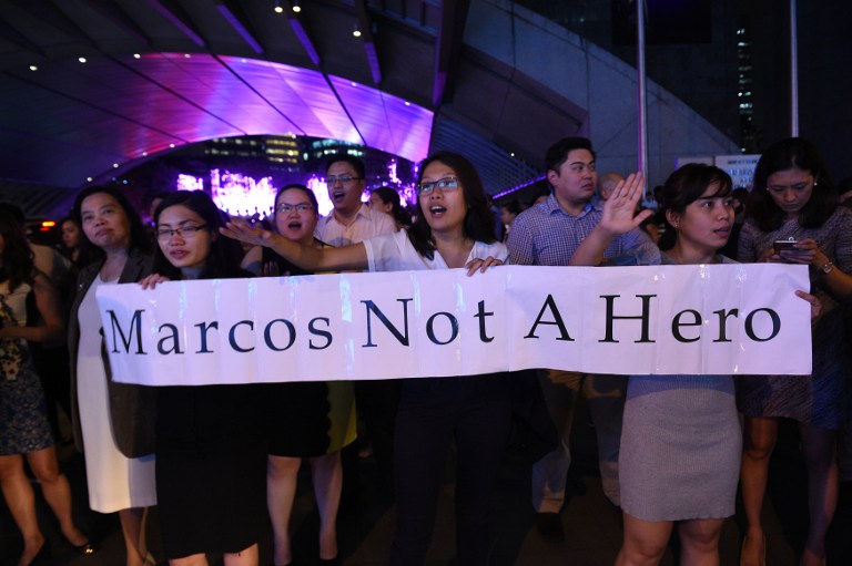 Protesters shout slogans as they ask motorists to honk their support as they demonstrate in Manila on November 18, 2016, following the burial of the late President Ferdinand Marcos.. / AFP PHOTO / TED ALJIBE