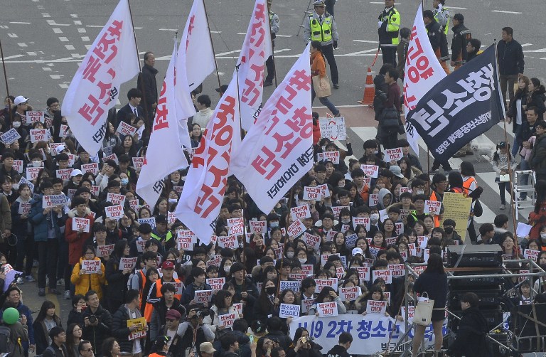 South Koreans take to the streets to demand President Park Geun-Hye to step down in Seoul on November 19, 2016. Tens of thousands of protestors gathered in Seoul for the fourth in a weekly series of mass protests aimed at forcing President Park Geun-Hye to resign over a corruption scandal. / AFP PHOTO / AFP PHOTO AND POOL / Kim Min-Hee