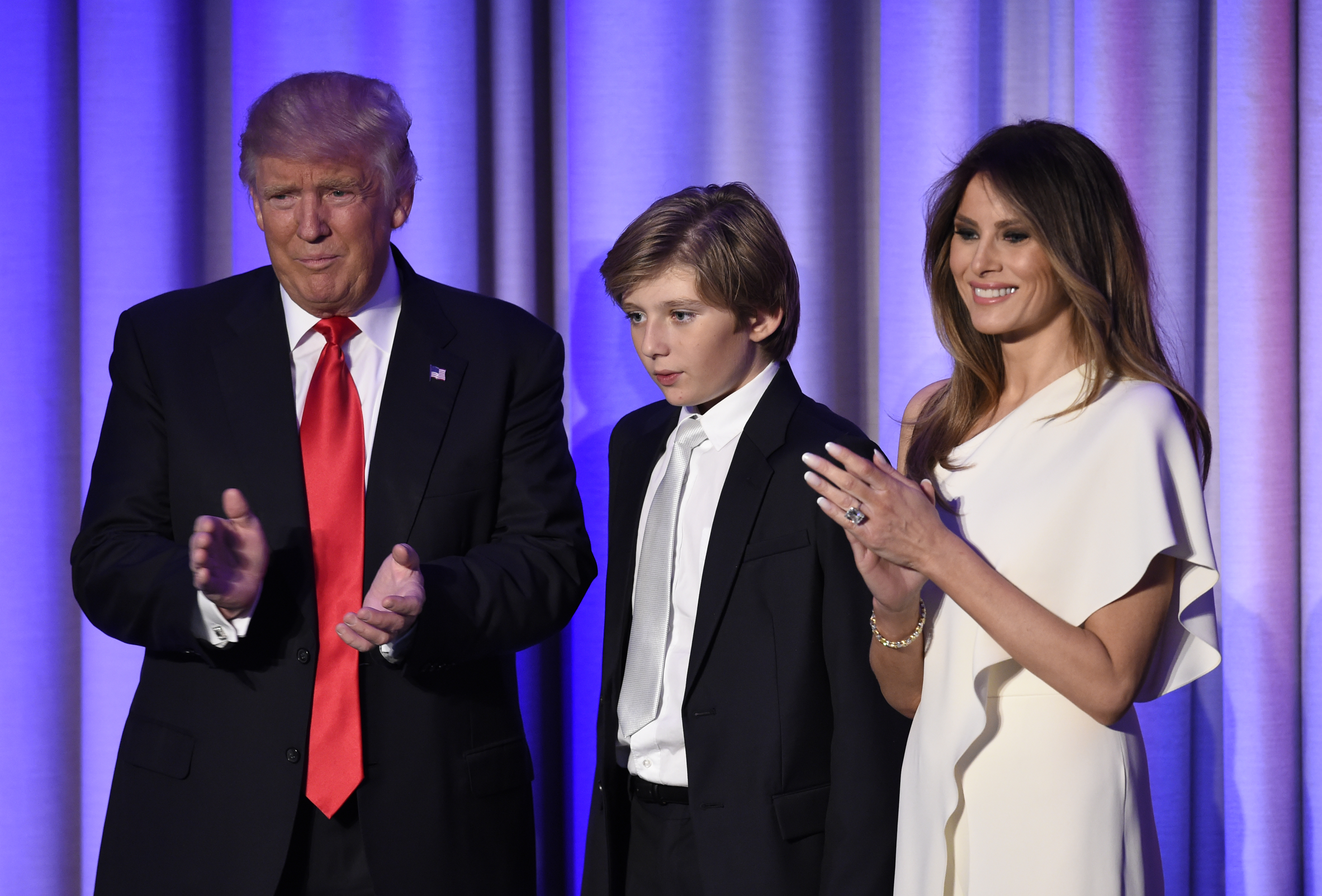 (FILES) This file photo taken on November 8, 2016 shows US President-elect Donald Trump arriving with his son Barron and wife Melania at the New York Hilton Midtown in New York on November 8, 2016.  Donald Trump's wife Melania and young son Barron will probably stay in New York when the president-elect moves into the White House, the transition team suggested November 20, 2016. The parents are wary of pulling their son out of school now, team communications director Jason Miller told reporters.  / AFP PHOTO / SAUL LOEB
