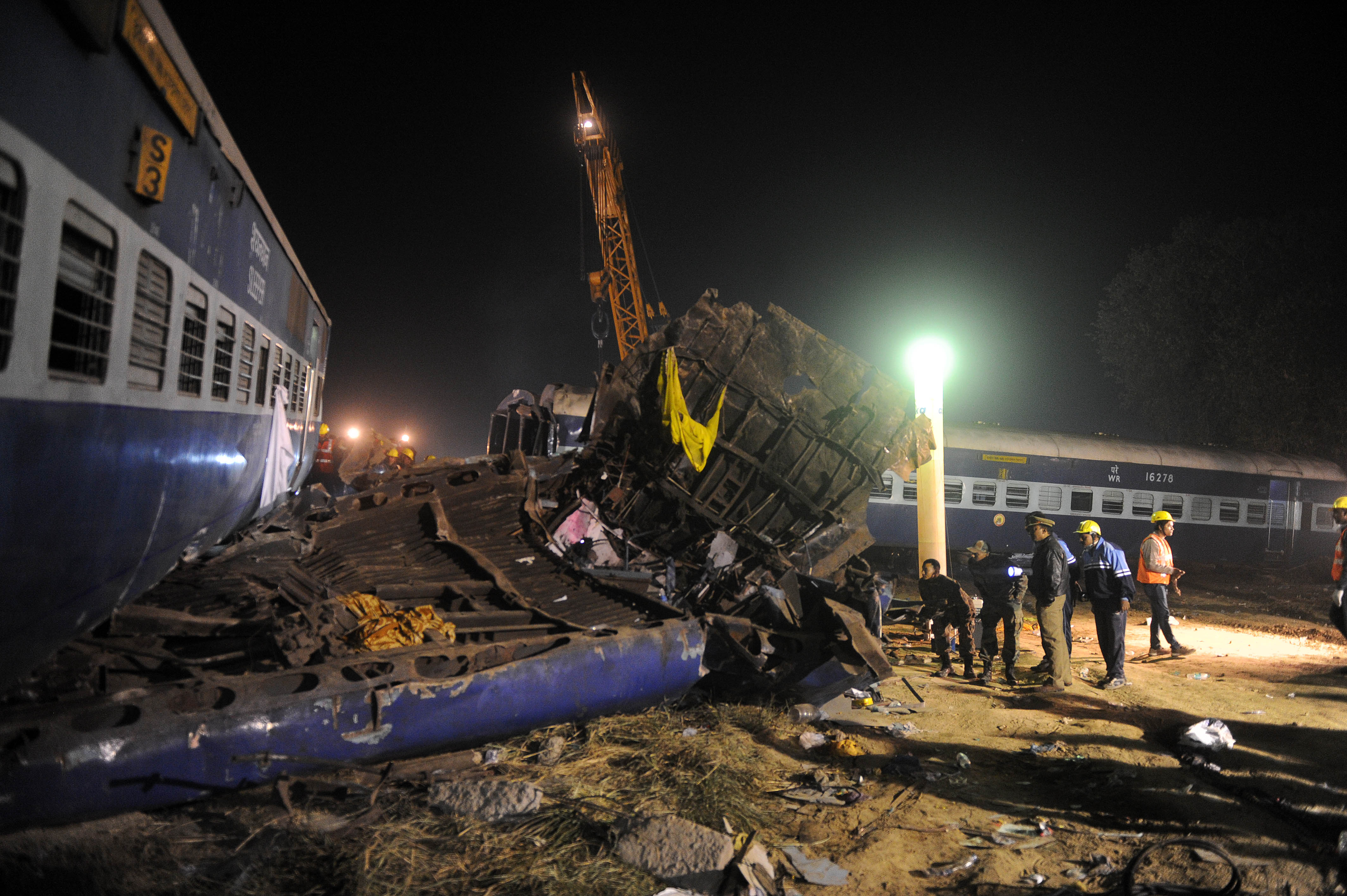 Rescue workers search for survivors in the wreckage of a derailed train near Pukhrayan in Kanpur district on November 20, 2016. Emergency workers raced to find any more survivors in the mangled wreckage of an Indian train that derailed on November 20, killing at least 120 people, in the worst disaster to hit the country's ageing rail network in recent years. Shocked passengers recalled being jolted out of their early morning slumber by a violent thud as 14 carriages leapt from the tracks in a remote area near Kanpur city in Uttar Pradesh state. / AFP PHOTO / SANJAY KANOJIA