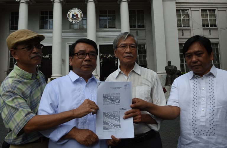 Former legislators and a leader of the opposition Neri Colmenares (2nd L) and former legislator and ex-communist rebel leader Satur Ocampo (2nd R) along with Bonifacio Ilagan (L) and human rights lawyer, Ephraim Cortez (R) present a copy of their petition for the exhumation of Marcos body at the Supreme court in Manila on November 21, 2016. Campaigners launched legal action on November 21, to exhume the body of former Philippine dictator Ferdinand Marcos, just three days after his burial in a national heroes' cemetery triggered street protests. / AFP PHOTO / TED ALJIBE