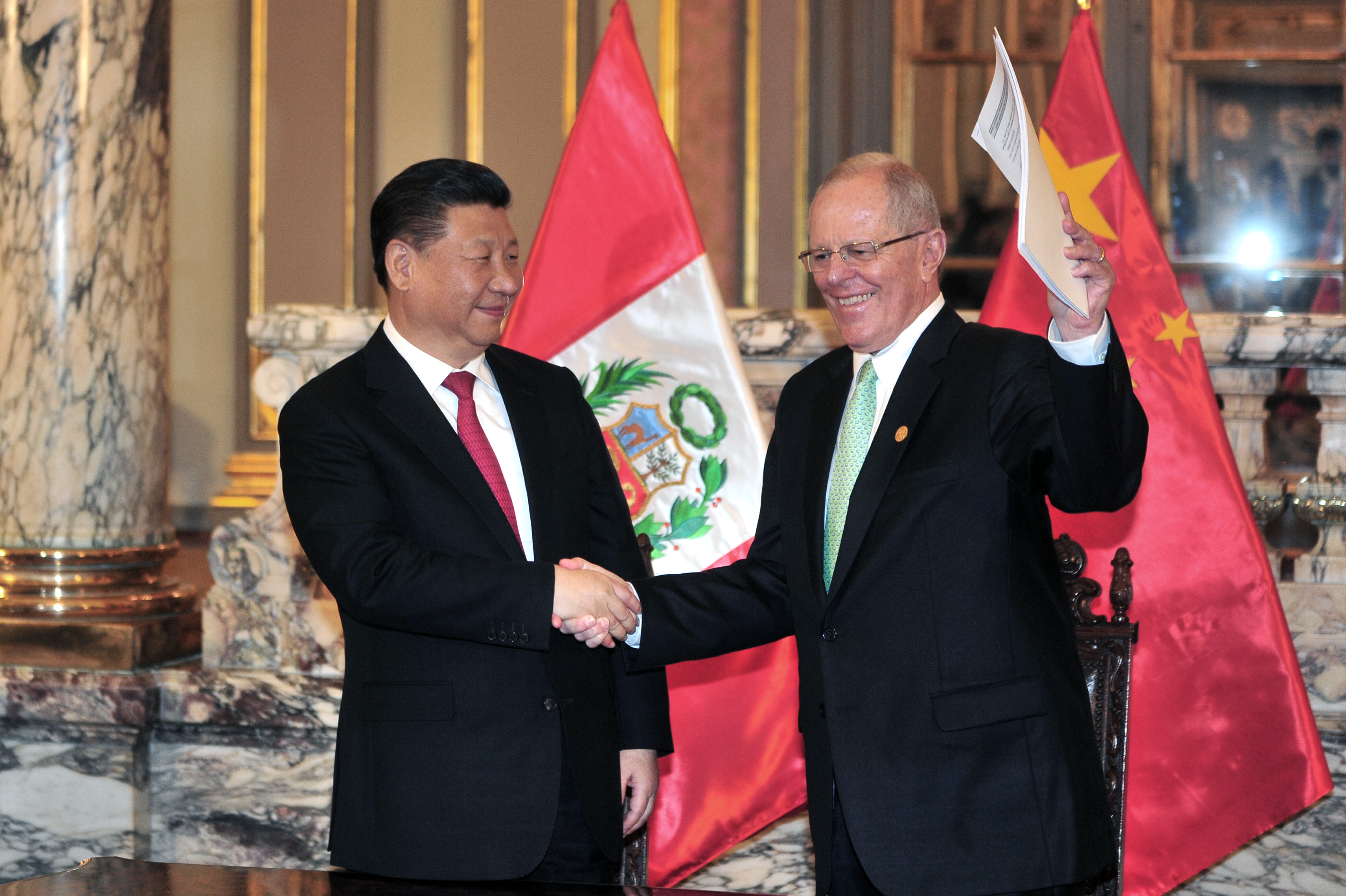 Peru's President Pedro Pablo Kuczynski (R) and China's President Xi Jinping (L) shake hands during a ceremony after signing bilateral agreements at the government palace in Lima on November 21, 2016.  / AFP PHOTO / RAFAEL ZARAUZ