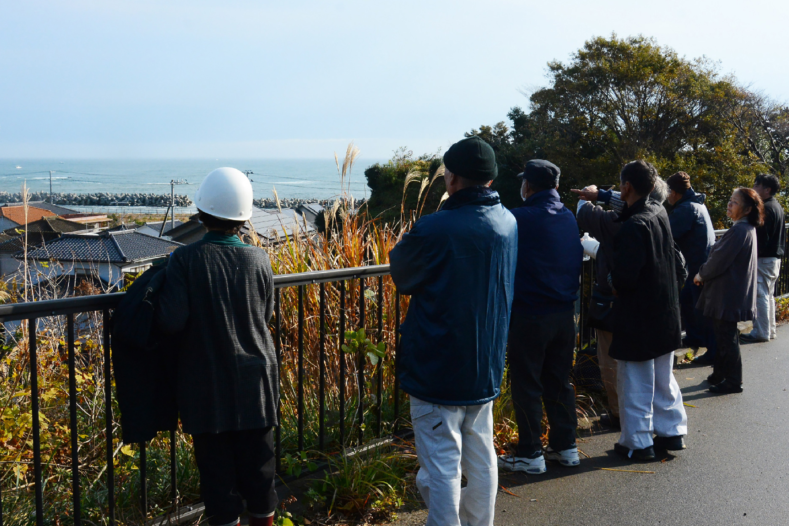 Local residents look out to sea from higher ground after evacuating their homes following an 6.9 magnitude earthquake and tsunami alert in Iwaki, Fukushima prefecture, on November 22, 2016. A powerful 6.9-magnitude earthquake hit northeastern Japan on November 22, triggering tsunamis along the coast including a one-metre (3.3-foot) wave that crashed ashore at the stricken Fukushima nuclear power plant. / AFP PHOTO / JIJI PRESS / JIJI PRESS / Japan OUT