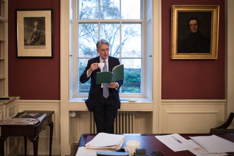 British Chancellor of the Exchequer Philip Hammond is pictured looking at his Autumn Statement in his office at 11 Downing Street in central London on November 22, 2016. Britain on Wednesday delivers its first budget since the Brexit referendum, with economists expecting a slight shift away from years of austerity as the nation readies its EU exit strategy. The Conservative government's finance minister Philip Hammond will deliver his so-called Autumn Statement before parliament around 1230 GMT Wednesday -- exactly five months after the Brexit vote. / AFP PHOTO / POOL / Stefan Rousseau