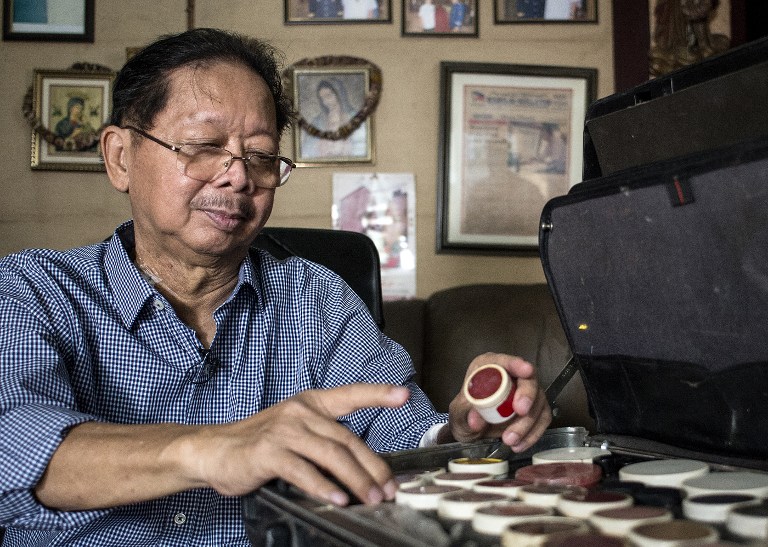 Frank Malabed, the embalmer of the late Philippine dictator Ferdinand Marcos, shows the make-up kit that he uses for his job during an interview in his office in Manila on November 22, 2016. A wax mask covered the face of Ferdinand Marcos for the 23 years his corpse was on show, but the body on display was no fake, the Philippine dictator's mortician told AFP in an interview. Frank Malabed, the embalmer of choice for high profile politicians and celebrities, revealed the secrets of his trade following the controversial burial at the Heroes' Cemetery in Manila last week. / AFP PHOTO / NOEL CELIS / TO GO WITH AFP STORY: "Philippines-Politics-Democracy-Marcos-Mortician", Interview by Cecil MORELLA