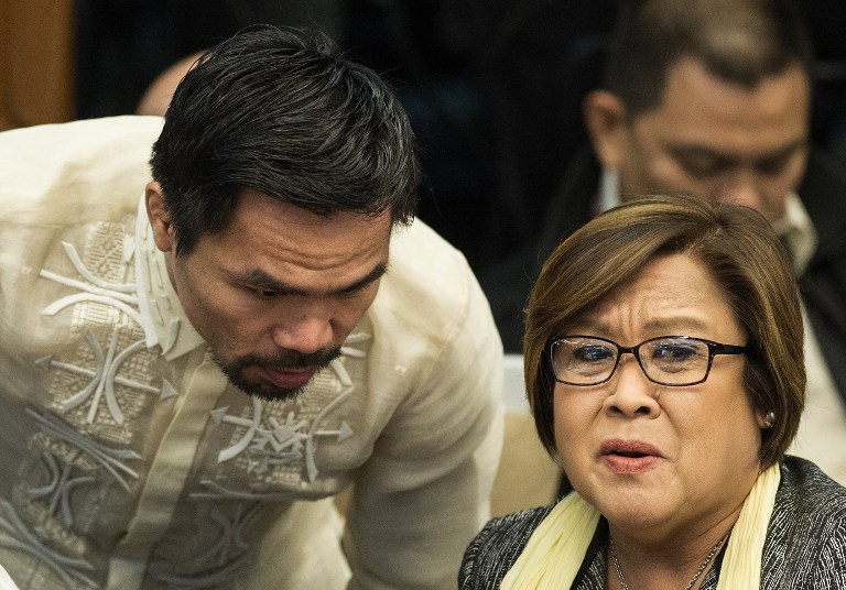Philippine boxing icon and Senator Manny Pacquiao (L) talks to Senator Leila De Lima during the Senate drug hearing at the Senate building in Manila on November 23, 2016. Kerwin Espinosa, son of the late mayor Rolando Espinosa, was arrested in the United Arab Emirates last month and will face drug trafficking charges. / AFP PHOTO / NOEL CELIS