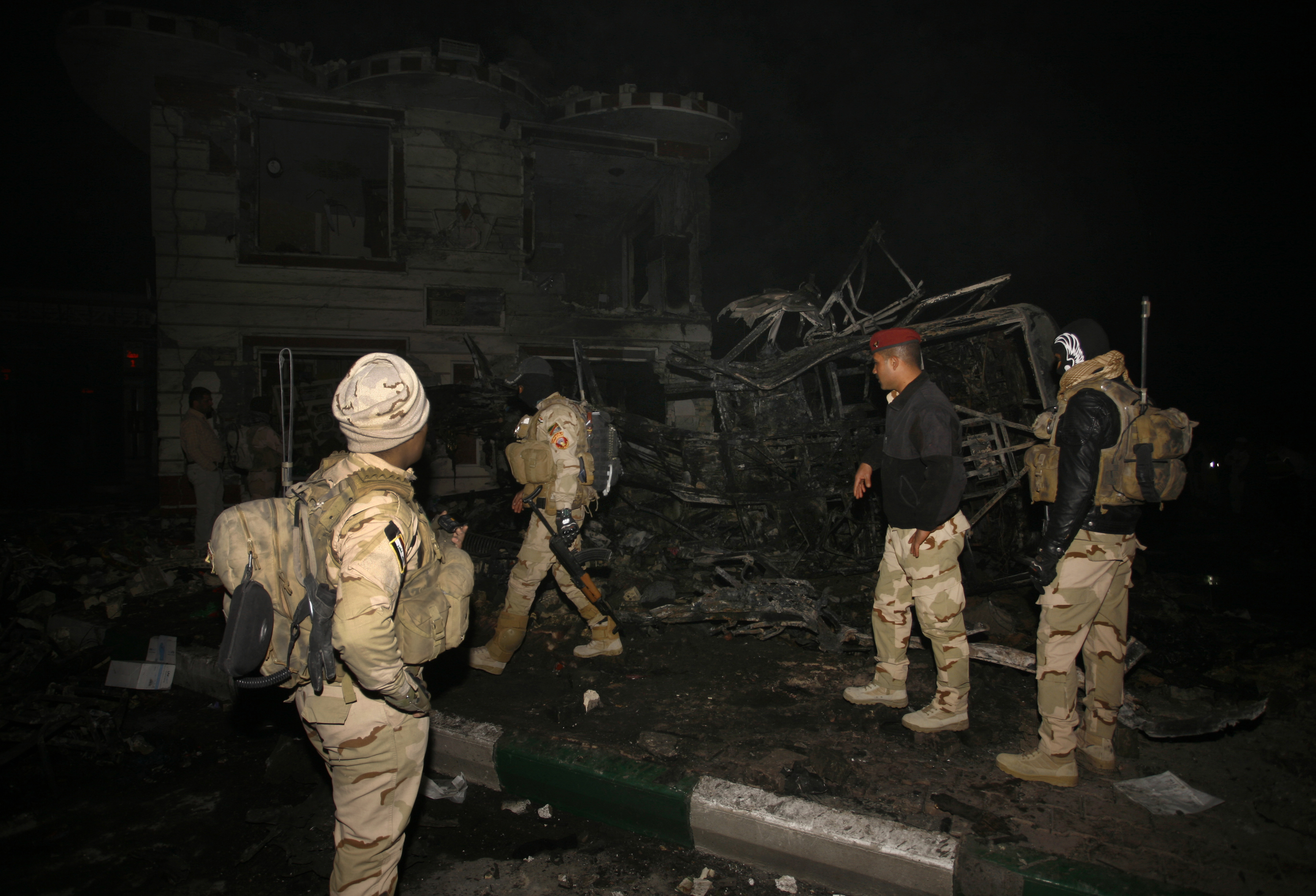 Iraqi security forces inspect the scene of a suicide bombing that targeted Shiite pilgrims returning from the Arbaeen commemoration in Karbala, on November 24, 2016, in the Shomali village, about 120 kilometres (75 miles) southeast of Baghdad. The suicide bombing claimed by the Islamic State group killed at least 70 people, mainly Shiite pilgrims, in the latest jihadist attack as Iraqi forces battle to retake Mosul. / AFP PHOTO / Haidar HAMDANI