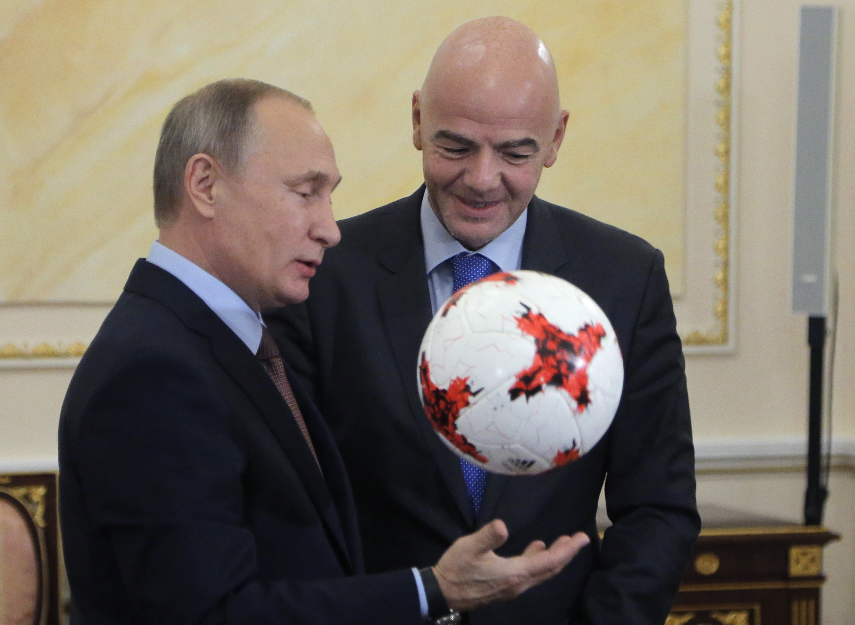 Russian President Vladimir Putin plays with an official match ball for the 2017 FIFA Confederations Cup, named "Krasava", as he meets with FIFA president Gianni Infantino at the Kremlin in Moscow on November 25, 2016 on the eve of the 2017 Confederations Cup draw to be held in Kazan. / AFP PHOTO / POOL / Maxim Shipenkov