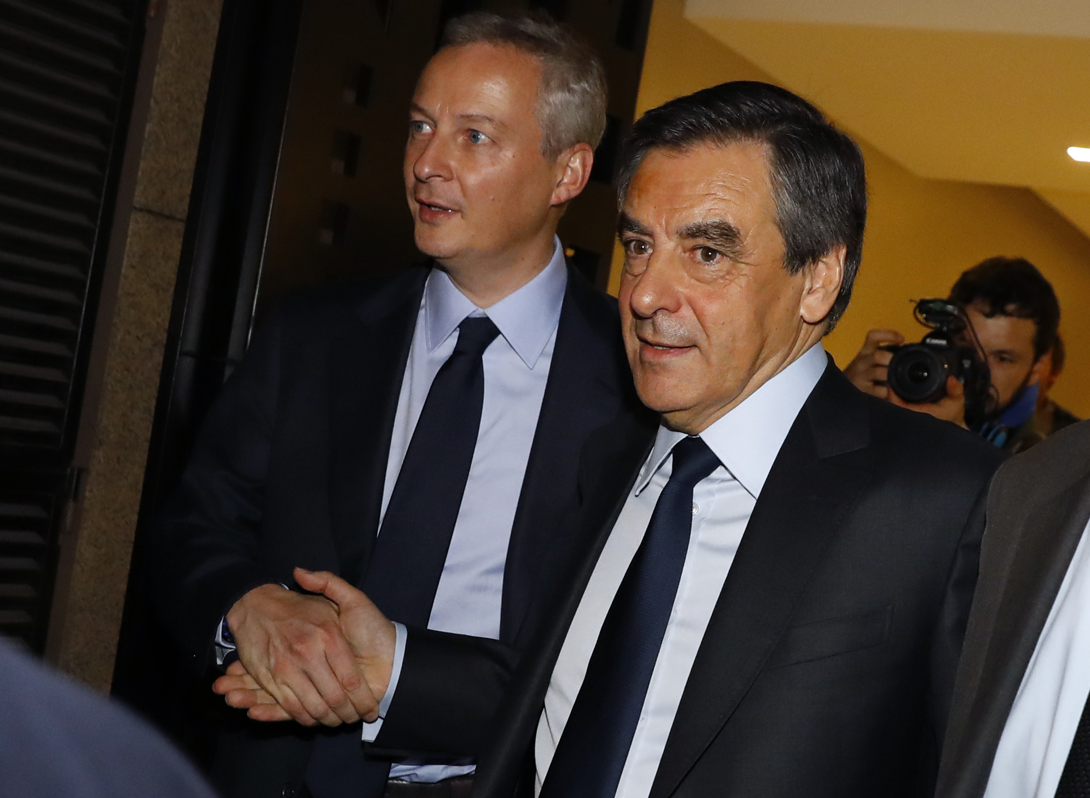Winner of the right-wing primaries ahead of France's 2017 presidential elections, Francois Fillon (R) shakes hands with Bruno Le Maire, French right-wing Les Republicains (LR) party member of Parliament and former candidate of the right-wing primaries who did not pass the first round (L), as he leaves after delivering a speech following the announcement of the results of the second round of the centre-right primaries ahead of France's 2017 presidential elections, at the primary's high authority headquarters on November 27, 2016, in Paris. France's conservatives held final run-off round of a primary battle on November 27 to determine who will be the right wing nominee for next year's presidential election. / AFP PHOTO / Patrick KOVARIK