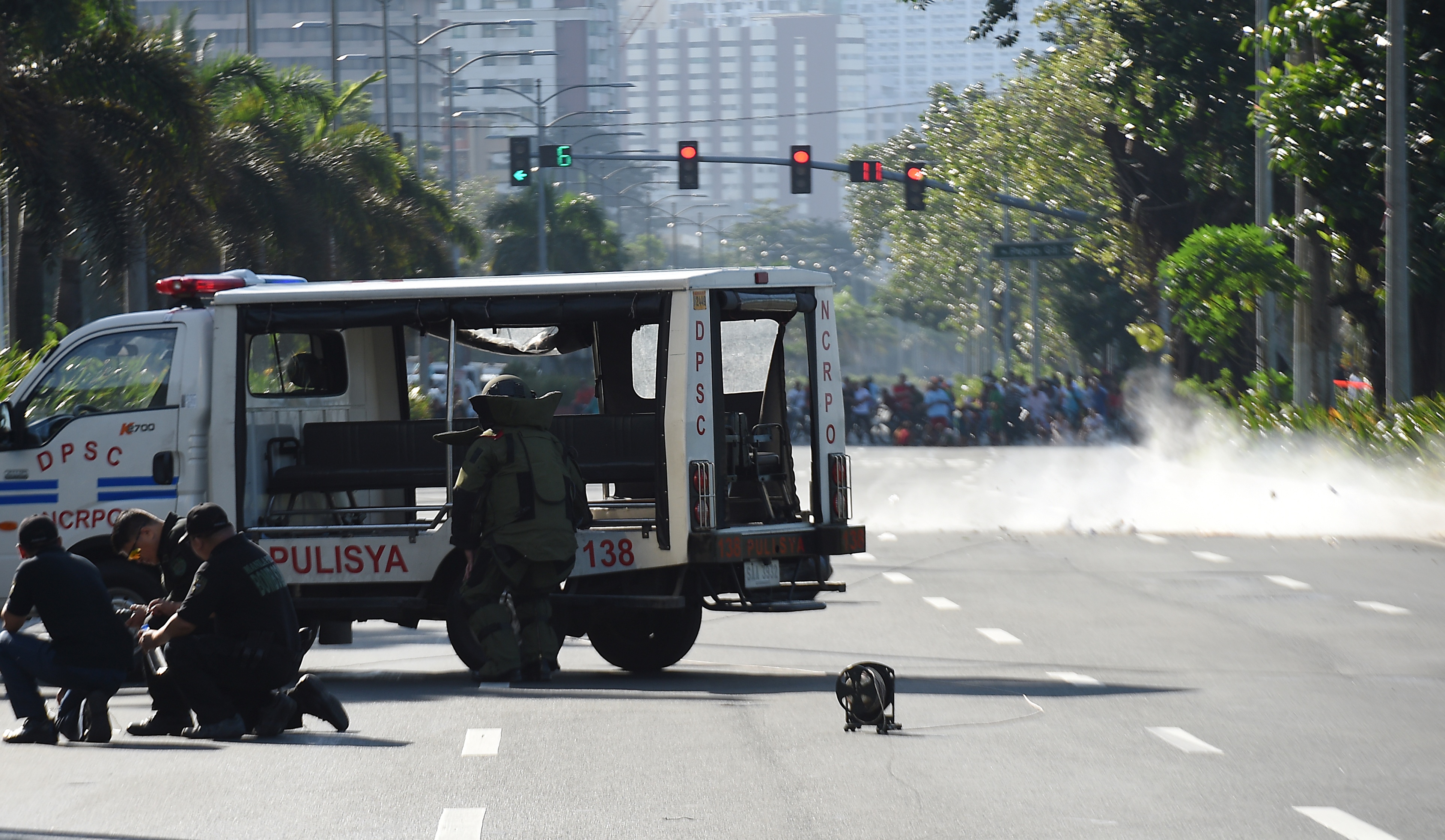 Members of police bomb disposal unit detonate a suspicious package along Roxas boulevard near the US embassy in Manila on November 28, 2016. According to press reports quoting the police, the suspicious package was found inside a box along a with a cell phone and another electronic device, which the police successfully detonated. / AFP PHOTO / TED ALJIBE