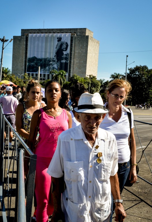 People queue to pay their last respects to Cuban revolutionary icon Fidel Castro at Revolution Square in Havana, on November 28, 2016.  A titan of the 20th century who beat the odds to endure into the 21st, Castro died late Friday after surviving 11 US administrations and hundreds of assassination attempts. No cause of death was given. Castro's ashes will go on a four-day island-wide procession starting Wednesday before being buried in the southeastern city of Santiago de Cuba on December 4. / AFP PHOTO / ADALBERTO ROQUE