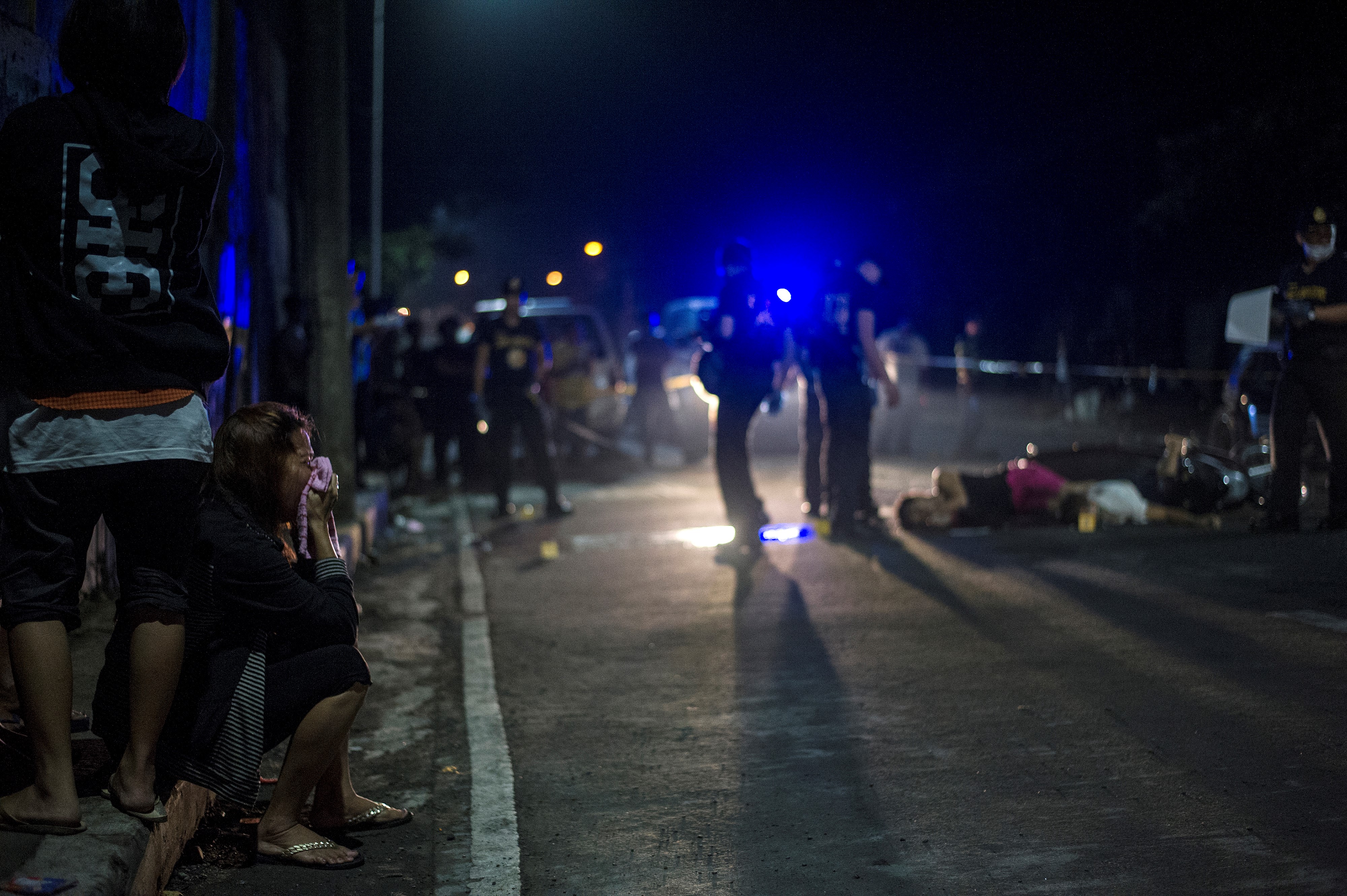 (FILES) This file photo taken on October 3,2016 shows relatives of alleged drug dealers gunned down by unidentified gunmen crying near the crime scene in Manila. The Philippines decried on November 29, 2016 as "irresponsible and alarming" a United Nations envoy's statement that life sentences against two former Khmer Rouge leaders should serve as a warning to Manila. David Scheffer, the UN Secretary-General's envoy to the tribunal, said rights abusers including in the Philippines, North Korea and the Islamic State (IS) group must "take note" of the verdict. / AFP PHOTO / NOEL CELIS