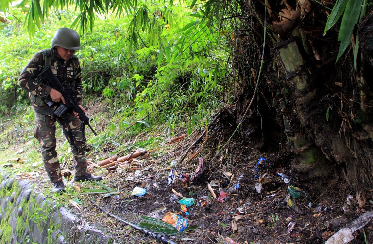 A soldier scours the site of a roadside blast in the village of Matampay in Marawi City, Southern Mindanao on November 29, 2016. Seven military bodyguards of President Rodrigo Duterte and two other soldiers were wounded on November 29 in an ambush by suspected Islamic militants on the eve of his planned visit to the southern Philippines, the military and president said. / AFP PHOTO / RICHEL UMEL