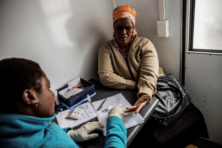 (FILES) This file photo taken on November 6, 2014 shows a South African woman getting tested for HIV by an health worker working with Doctors withouy borders (MSF) at a mobile clinic in Eshowe.  South Africa on November 30, 2016 begins a major clinical trial of an experimental vaccine against AIDS, which scientists hope could be the "final nail in the coffin" for the disease. More than 30 years of efforts to develop an effective vaccine for HIV have not borne fruit, but for the first time since the virus was identified in 1983, scientists think they have found a promising candidate. / AFP PHOTO / GIANLUIGI GUERCIA