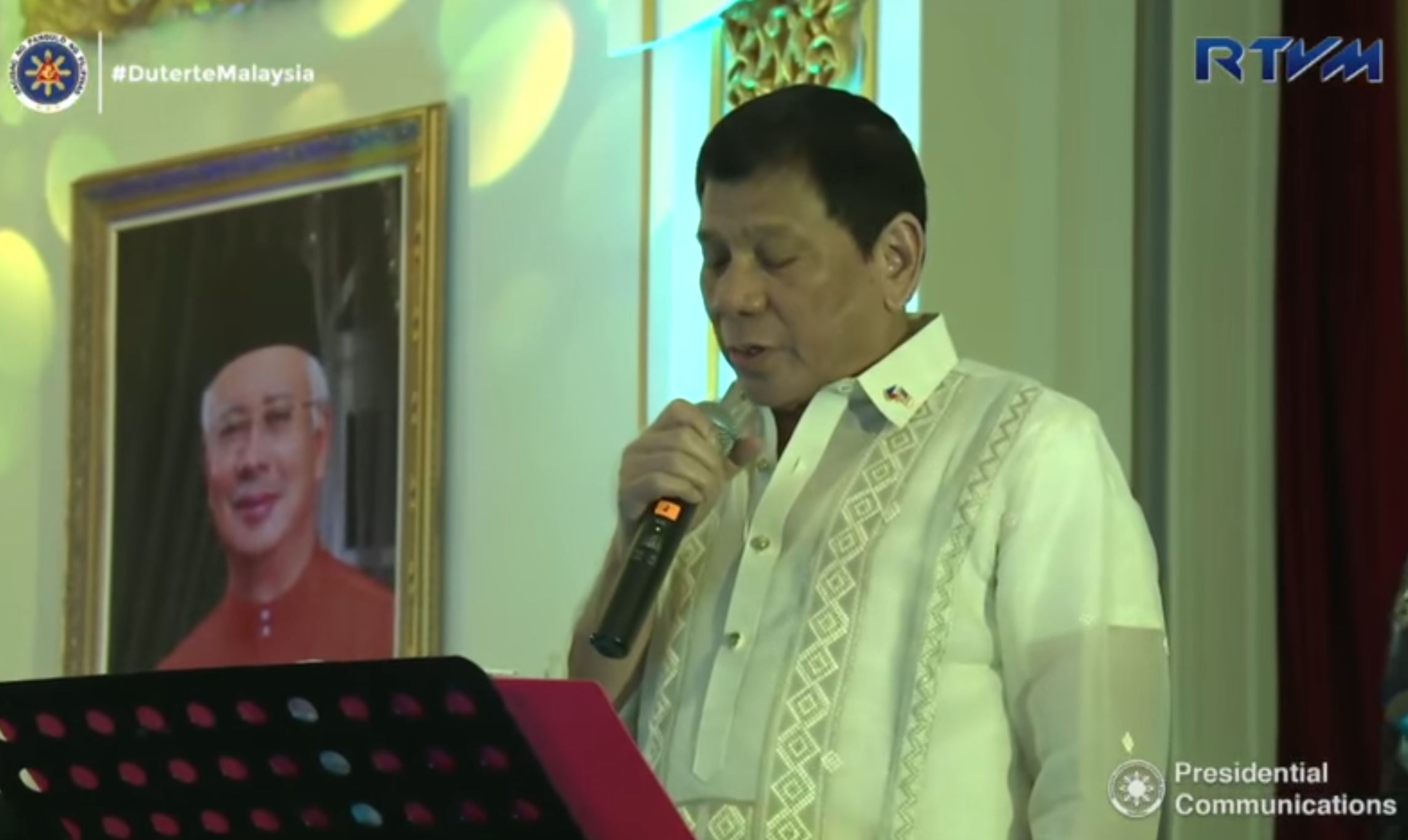 President Duterte singing singing Bette Midler's "Wind Beneath My Wings" during the dinner hosted by Malaysian Prime Minister Najib Razak. (Photo grabbed from RTVM video).