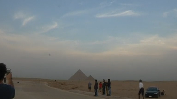 A vintage biplane flew by and landed near Egypt's iconic pyramids of Giza, on the second leg of a month-long journey through Africa. (Photo grabbed from Reuters video)