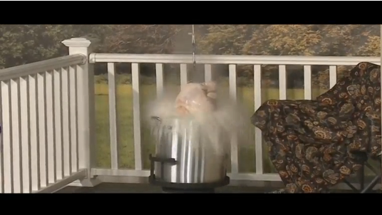 Frozen turkey being lowered in the into hot deep fryer when the oil explodes, sending fires in the different parts of the prototype house. (Photo courtesy of Reuters video file)