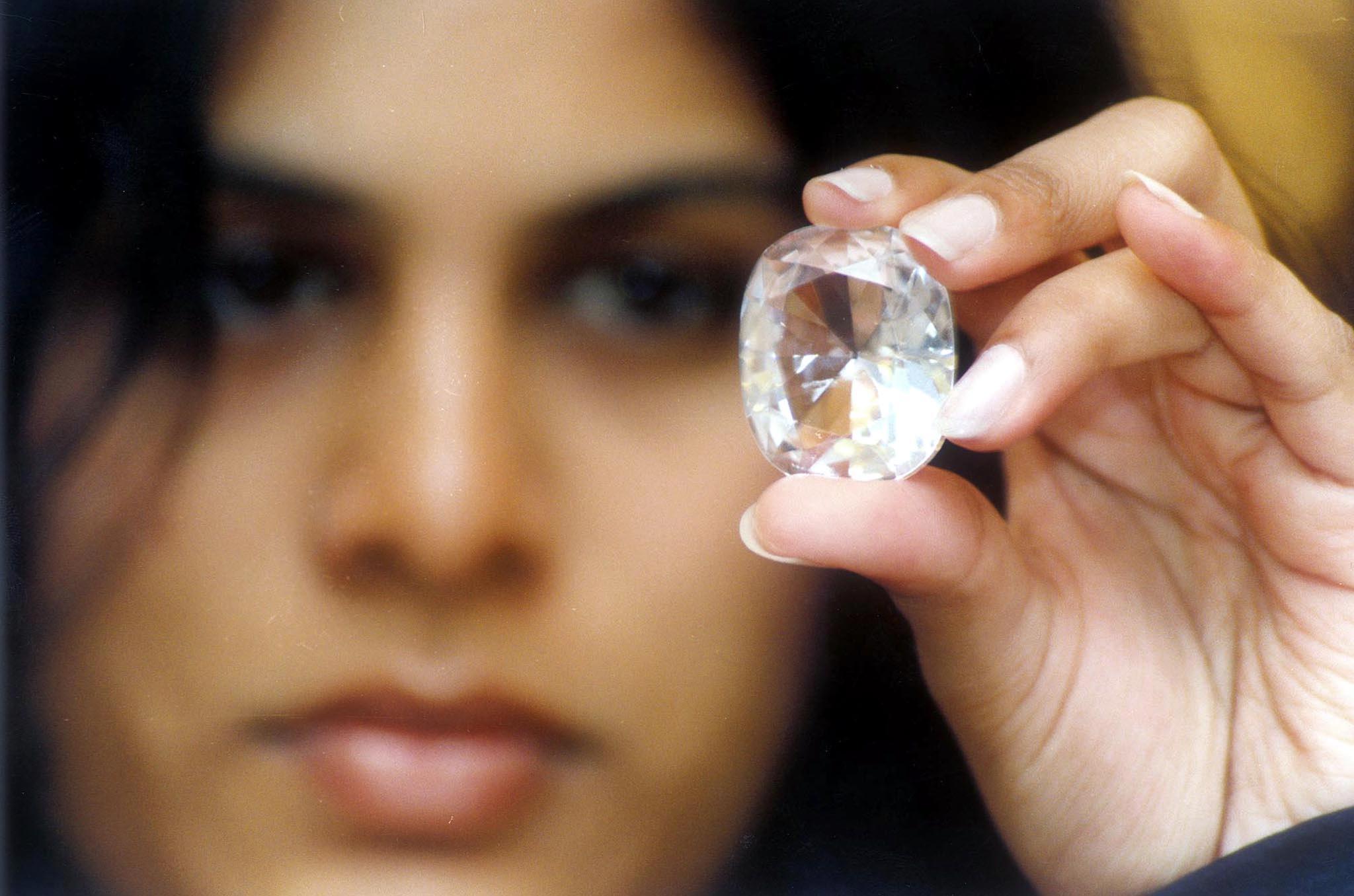 Executive Director of Jewels de Paragon (JDP) Pavana Kishore shows the "Koh-I-Noor" diamond on display with other famous diamonds at an exhibition intitled "100 World Famous Diamonds" in Bangalore 19 May 2002. The Koh-I-Noor diamond, which once belonged to Mughal Emperor Shah Jehan, weighs 105.60 Carats and is part of the British crown jewels, stored in the tower of London. AFP PHOTO / AFP PHOTO / STR