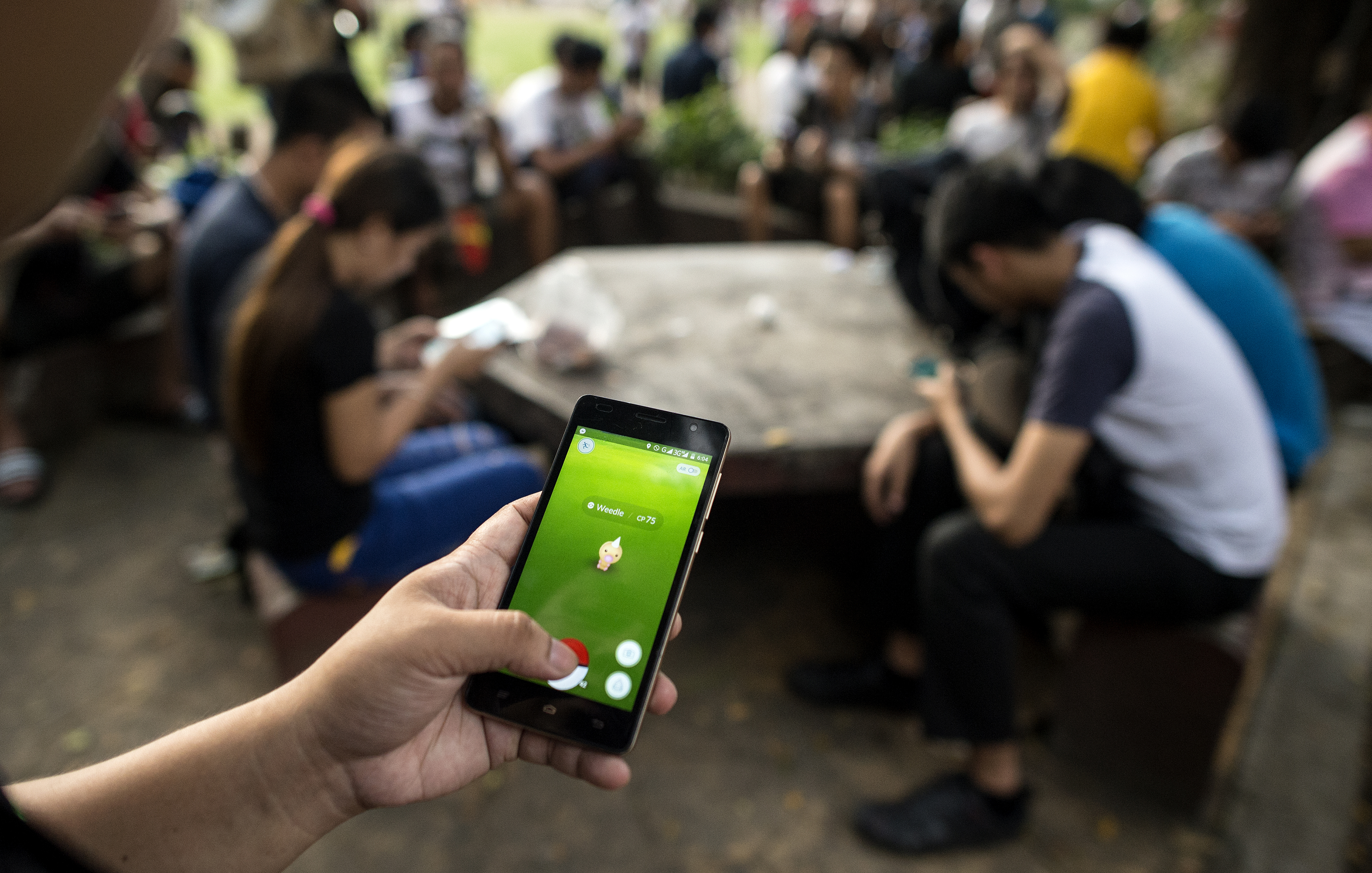 FILE PHOTO: Gamers play Pokemon Go at the Quezon City Memorial Circle in Manila on August 23, 2016. A Philippine city councillor has sought to stop Pokemon Go players in government from losing "productivity" by filing a resolution to ban the hunt for digital monsters in state offices. / AFP PHOTO / NOEL CELIS