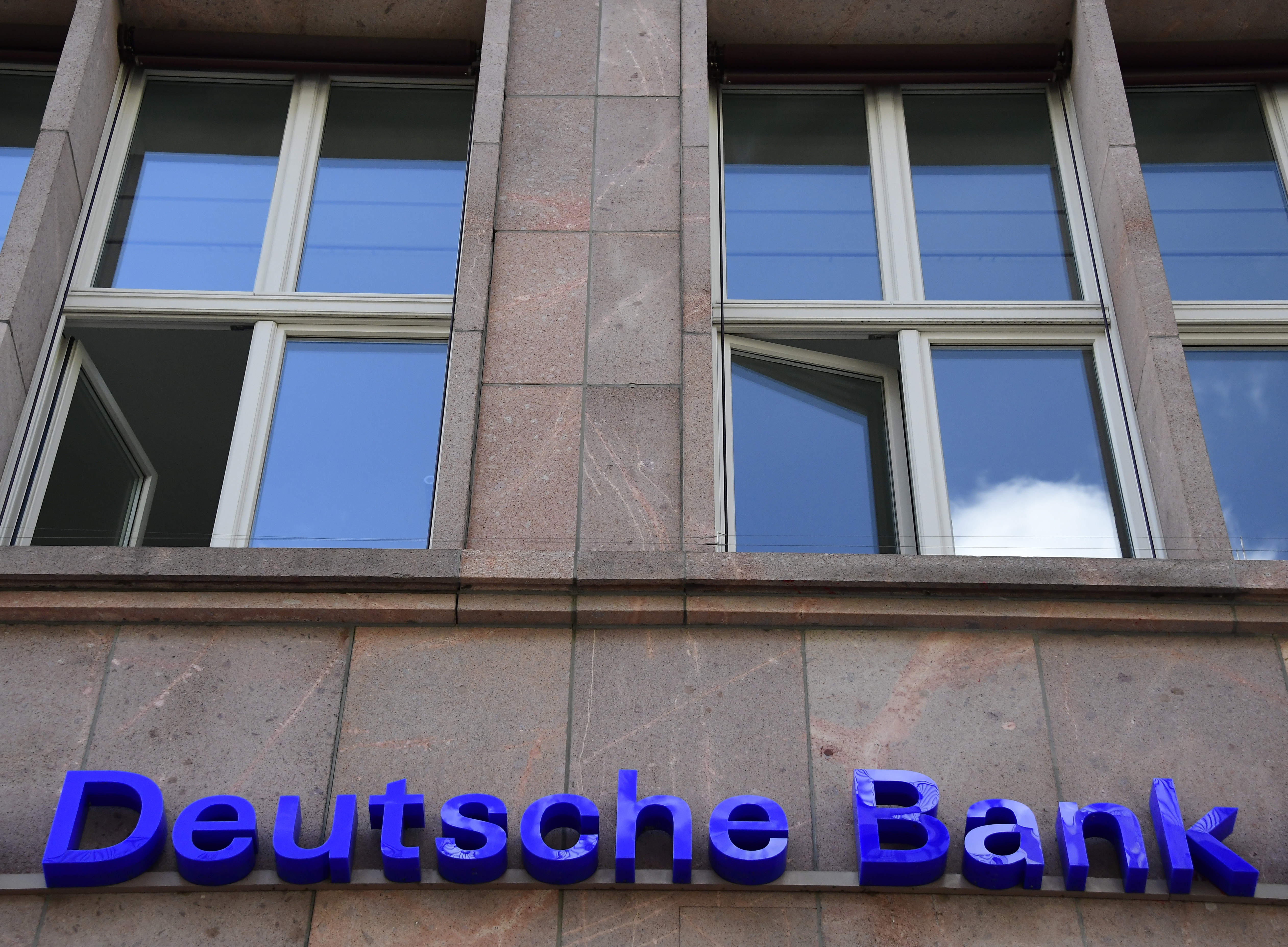 The logo of Germany's biggest lender Deutsche Bank is seen on a branch of the bank in Berlin's Mitte district on September 30, 2016. Shares in Deutsche Bank plummeted on the Frankfurt stock market, dragging other European banks and global markets down with it, after reports some customers were pulling money out. / AFP PHOTO / TOBIAS SCHWARZ