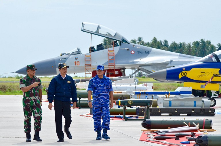 This handout photograph taken and released by the Presidential Palace on October 6, 2016 shows Indonesian President Joko Widodo (C) walking next to Indonesian Military Chief General Gatot Nurmantyo (L) and Air Force Chief of Staff Air Marshal Agus Supriatna (R) during a military drill on the remote Natuna islands. The Indonesian Air Force on October 6 held a major exercise around its island in the South China Sea where there have been clashes with Chinese vessels in waters claimed by Beijing. / AFP PHOTO / PRESIDENTIAL PALACE / AGUS SUPARTO / RESTRICTED TO EDITORIAL USE - MANDATORY CREDIT "AFP PHOTO / PRESIDENTIAL PALACE" - NO MARKETING NO ADVERTISING CAMPAIGNS - DISTRIBUTED AS A SERVICE TO CLIENTS