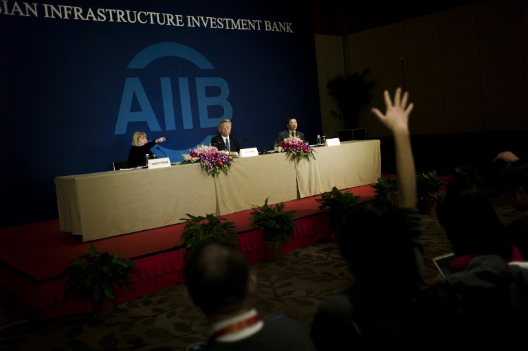Jin Liqun (C), the first president of the Asian Infrastructure Investment Bank (AIIB), speaks to journalists during a press conference in Beijing on January 17, 2016. The new Asian Infrastructure Investment Bank will boost investment in the region while contributing to "fairer" global economic governance, Chinese President Xi Jinping said on January 16 at the formal opening ceremony in Beijing. The China-backed AIIB -- which has 57 members including major economies such as Australia and South Korea but notably excluding the US and Japan -- is viewed by some as a rival to the World Bank and Asian Development Bank (ADB). AFP PHOTO / FRED DUFOUR / AFP PHOTO / FRED DUFOUR