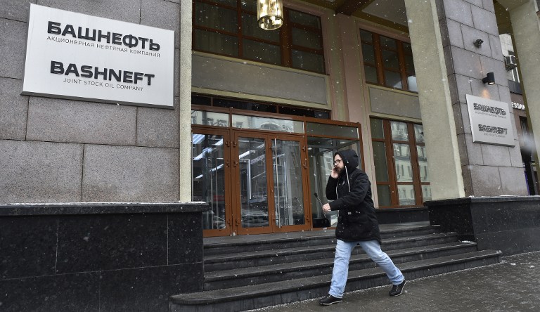 A man speaks on a mobile phone as he walks past the headquarters of Russian oil producer Bashneft in Moscow on November 15, 2016. Russia on November 15 charged Economy Minister Alexei Ulyukayev with bribe-taking after he was detained on suspicion of accepting a two-million-dollar payoff over a deal involving state-controlled oil giant Rosneft.  / AFP PHOTO / Alexander NEMENOV