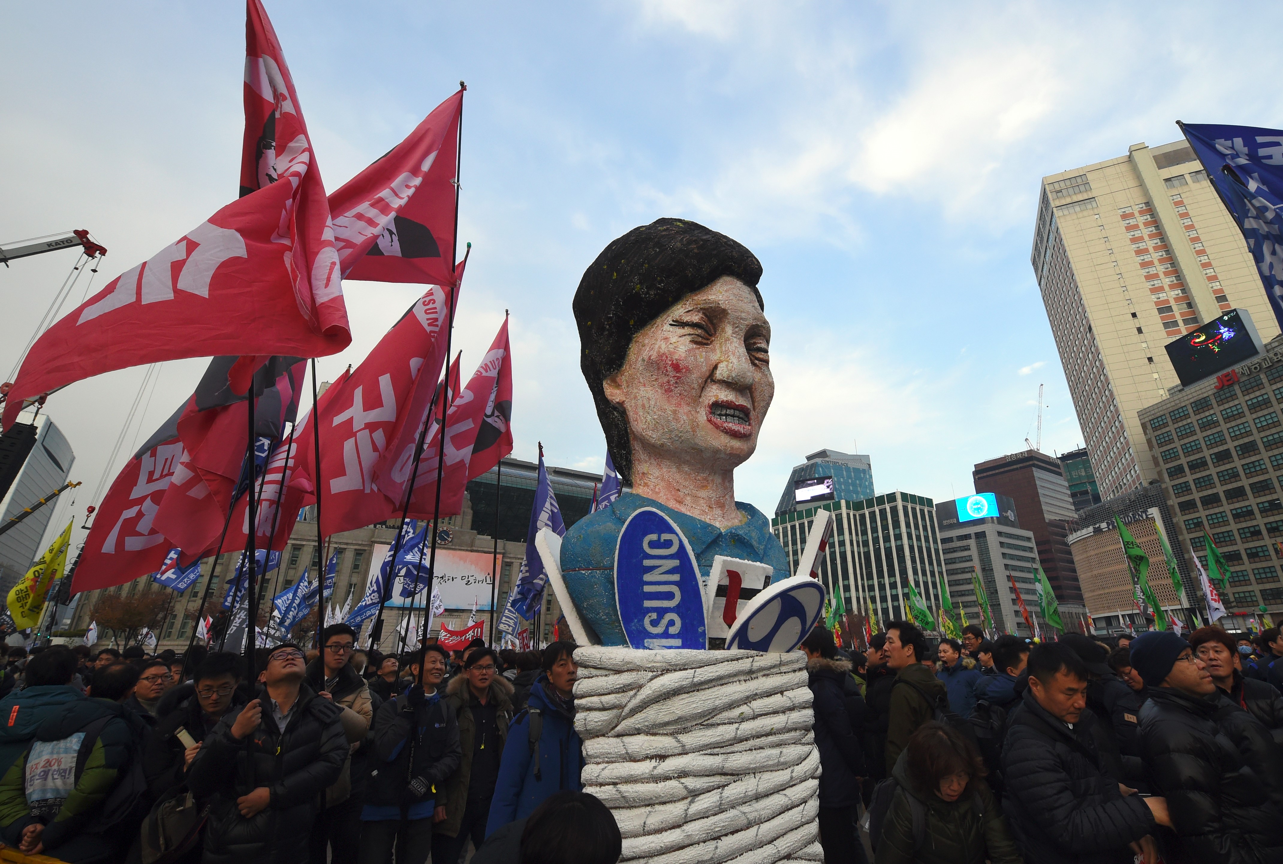 Protesters carry an effigy of South Korea's President Park Geun-Hye during an anti-government rally demanding the resignation of the president in central Seoul on November 30, 2016. An impeachment vote against South Korea's scandal-hit president will be postponed by at least a week, lawmakers said on November 30, after Park Geun-Hye announced she was willing to stand down early. / AFP PHOTO / JUNG Yeon-Je