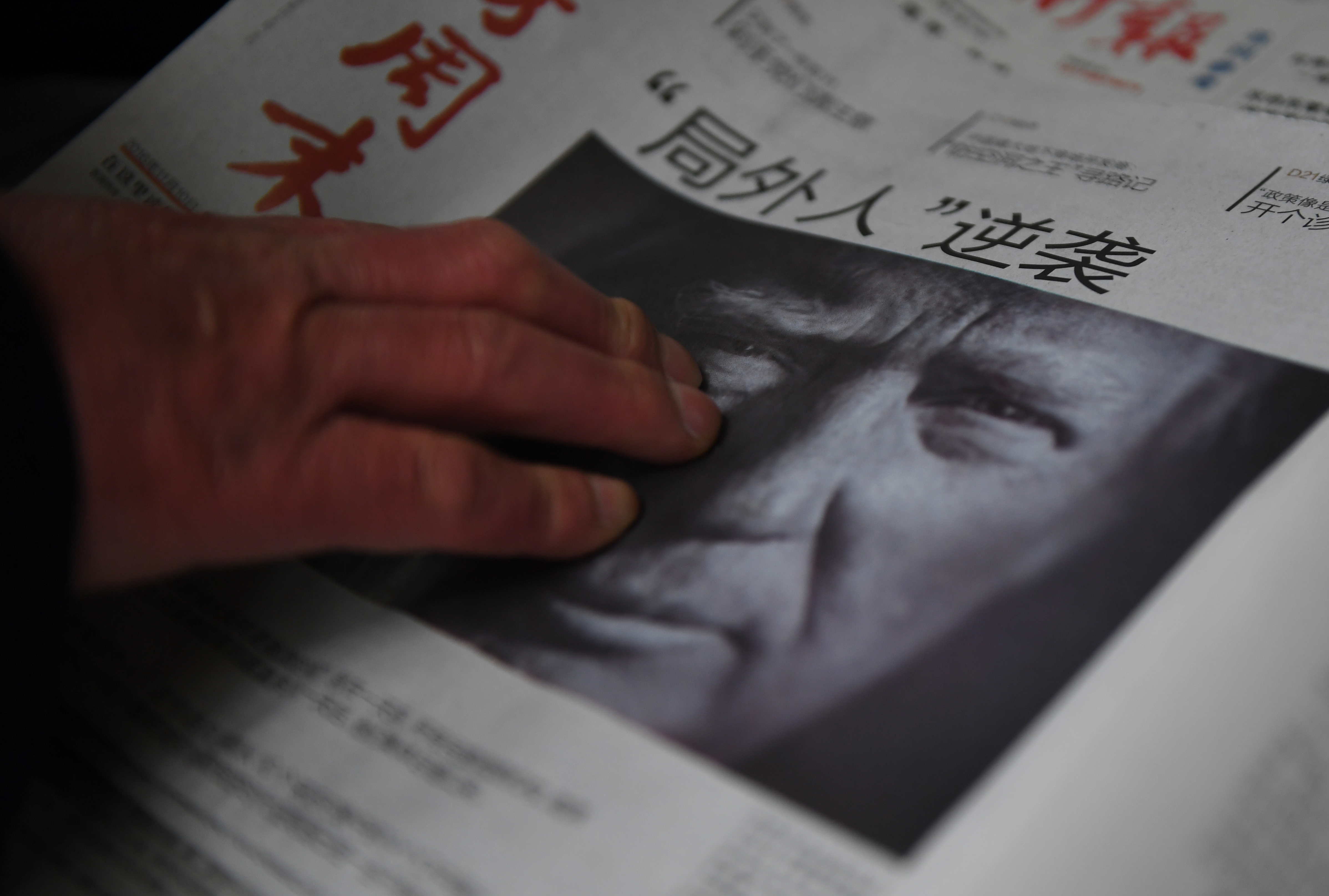 (FILES) This file photo taken on November 10, 2016 shows a man buying a newspaper featuring a photo of US President-elect Donald Trump, the day after the US election, at a news stand in Beijing on November 10, 2016. The headline reads "Outsider strikes back". President-elect Donald Trump broke with decades of cautious US diplomacy on December 2 to speak with the president of Taiwan, at the risk of provoking a serious rift with China. / AFP PHOTO / GREG BAKER