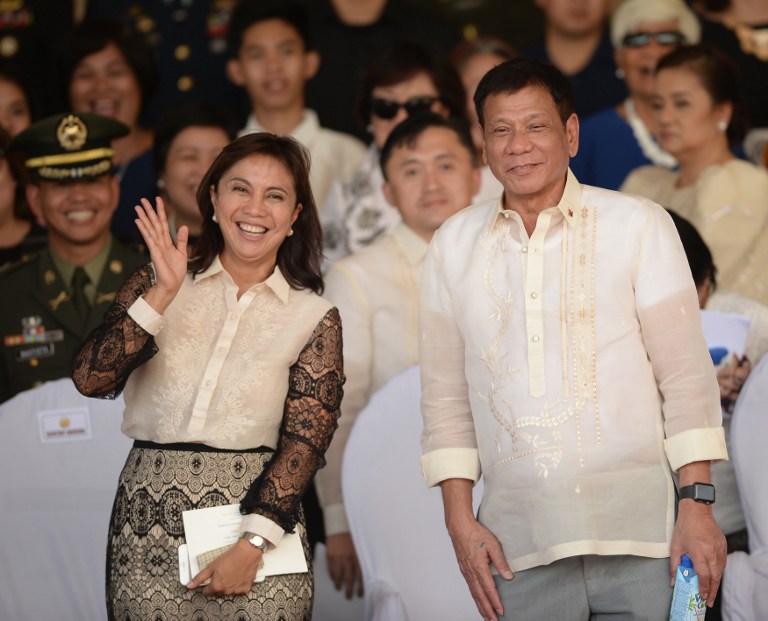 (FILES) This file photo taken on July 1, 2016 shows Philippines' President Rodrigo Duterte (R) posing for photographs with Vice-President Leni Robredo after the military parade at the military headquarters in Manila. Philippine Vice-President Leni Robredo said on December 4, 2016 she was told that President Rodrigo Duterte had barred her from cabinet meetings, and alleged there was a plot to oust her as his deputy. / AFP PHOTO / Ted ALJIBE