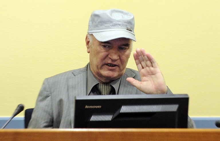 (FILES) This file photo taken on June 3, 2011 at the UN Yugoslav war crimes tribunal in The Hague shows wartime Bosnian Serb General Ratko Mladic wearing a cap saluting in the court room at his initial appearance. Former feared Serb military commander Ratko Mladic, once dubbed "The Butcher of Bosnia", is back in a UN court on December 5, 2016 as his trial for genocide and war crimes in the 1990s conflict nears an end, as prosecutors will begin three days of closing arguments and will likely call for a long jail term for genocide, as well as war crimes and crimes against humanity for his role in the bloody 1992-95 Bosnian conflict which saw Europe's worst bloodshed since World War II. / AFP PHOTO / POOL / MARTIN MEISSNER
