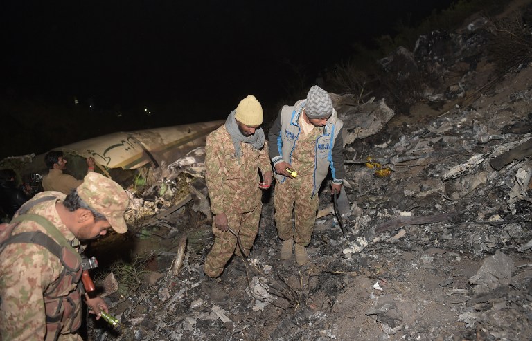 Pakistani soldiers search for victims from the wreckage of the crashed PIA passenger plane Flight PK661 at the site in the village of Saddha Batolni in the Abbottabad district of Khyber Pakhtunkhwa province on December 7, 2016. All 48 people on board a Pakistani plane which crashed in the country's mountainous north and burst into flames have died, officials told AFP on December 7, 2016. "No one survived," said the Civil Aviation Authority spokesman. / AFP PHOTO / AAMIR QURESHI