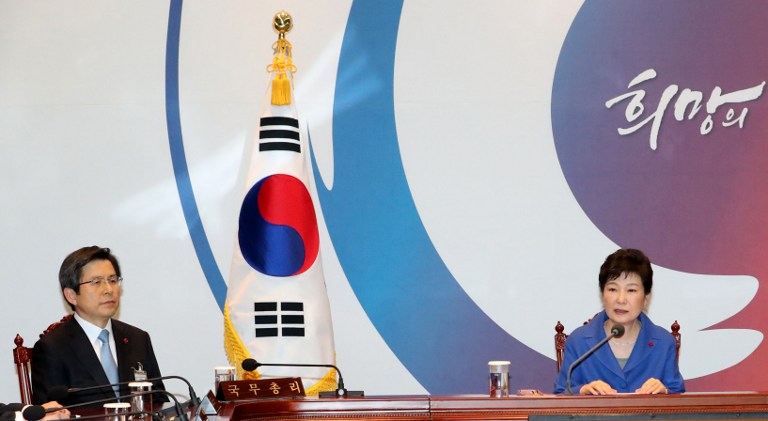 South Korean President Park Geun-Hye (R) speaks as Prime Minister Hwang Kyo-Ahn (L) listens during an emergency cabinet meeting at the presidential Blue House in Seoul on December 9, 2016. Impeached South Korean President Park Geun-Hye apologised on December 9 for the political "chaos" in the country and urged the government to remain vigilant on the economy and national security. / AFP PHOTO / YONHAP / YONHAP