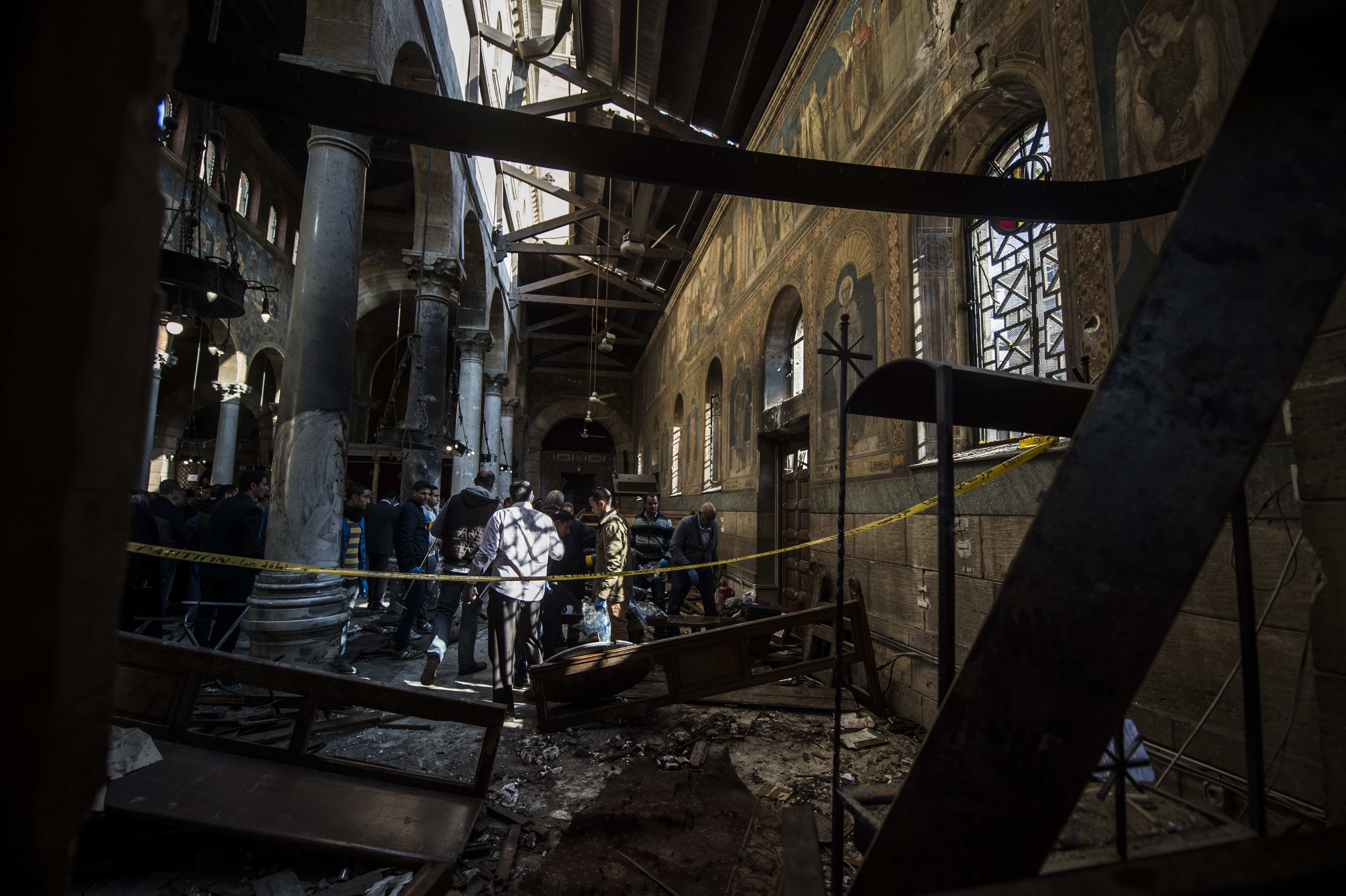 Egyptian security forces inspect the scene of a bomb explosion at the Saint Peter and Saint Paul Coptic Orthodox Church on December 11, 2016, in Cairo's Abbasiya neighbourhood. The blast killed at least 25 worshippers during Sunday mass inside the Cairo church near the seat of the Coptic pope who heads Egypt's Christian minority, state media said. / AFP PHOTO / KHALED DESOUKI