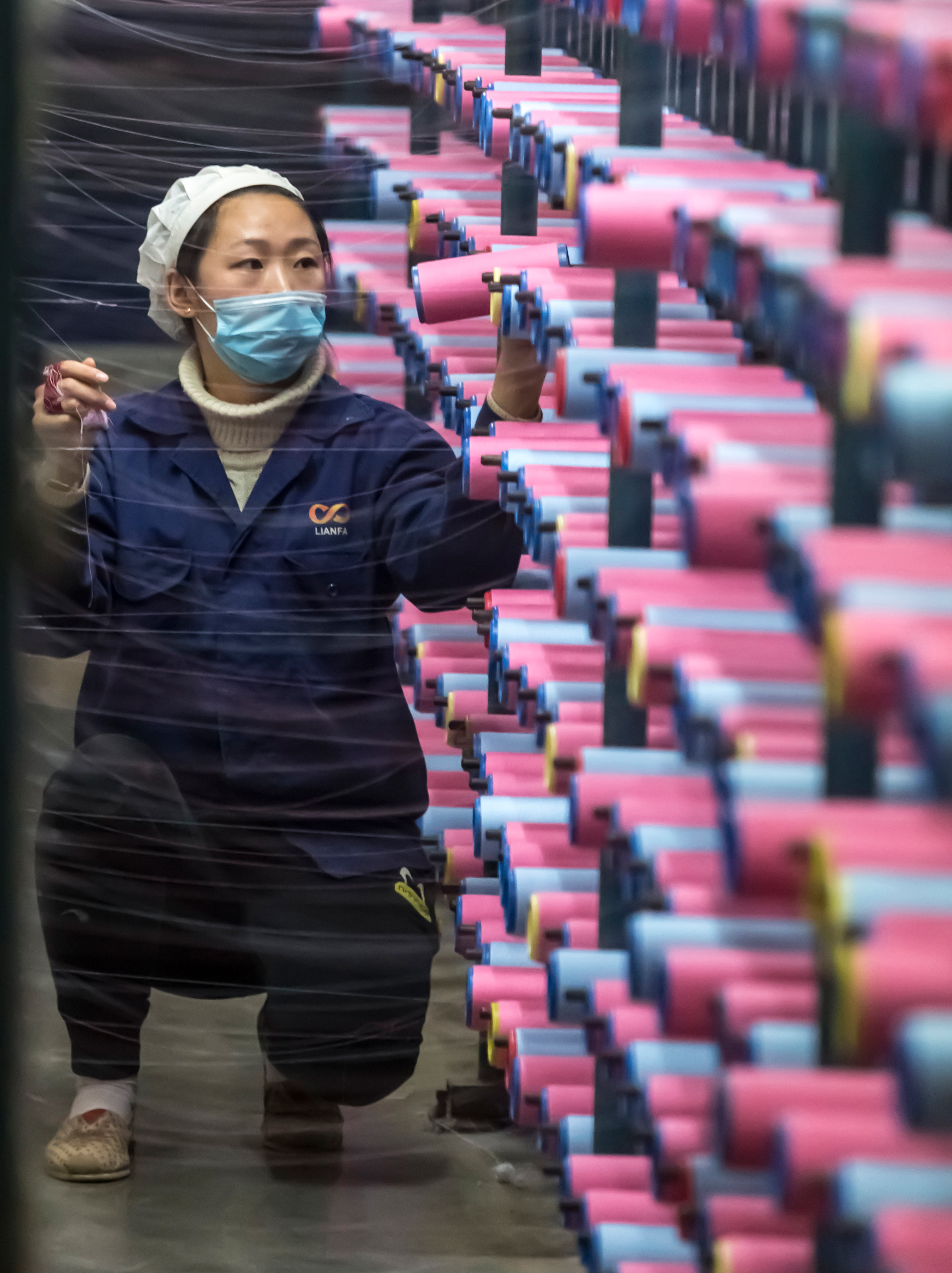 This picture taken on December 10, 2016 shows a woman working in a textile factory in Nantong in China's eastern Jiangsu province.  China's industrial output rose 6.2 percent year-on-year in November, government data showed on December 13, accelerating slightly from the previous month in a sign of stabilisation for the world's second-largest economy.  / AFP PHOTO / STR / China OUT