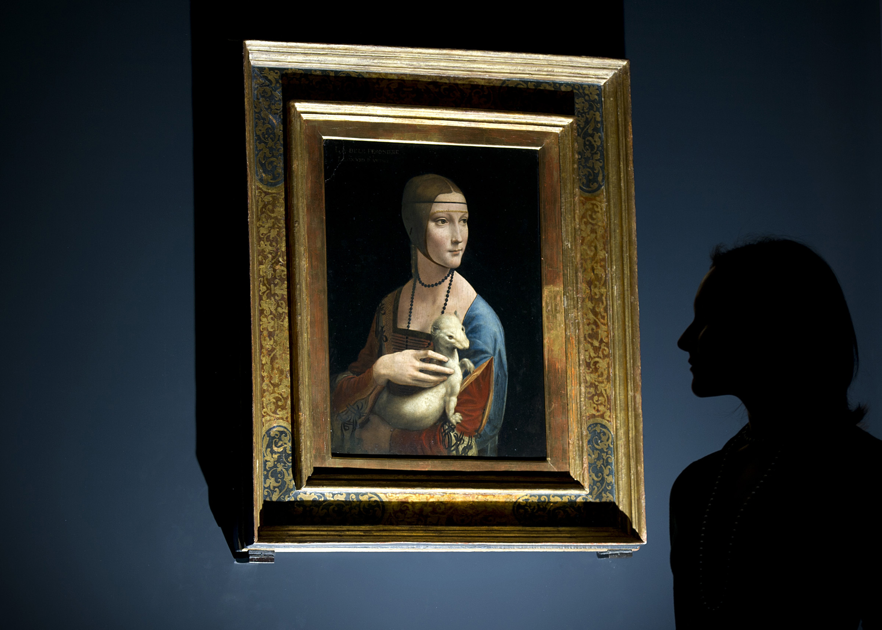 (FILES) This file photo taken on November 7, 2011 shows a woman posing for pictures beside a painting entitled 'Portrait of Cecilia Gallerani' (The Lady with an Ermine) by Italian artist Leonardo da Vinci during a photocall at the National Gallery in London. As it was confirmed on December 13, 2016, the Polish State would like to buy back the famous painting from the Czartoryski princes' family. / AFP PHOTO / CARL COURT / RESTRICTED TO EDITORIAL USE - MANDATORY MENTION OF THE ARTIST UPON PUBLICATION - TO ILLUSTRATE THE NEWS AS SPECIFIED IN THE CAPTION