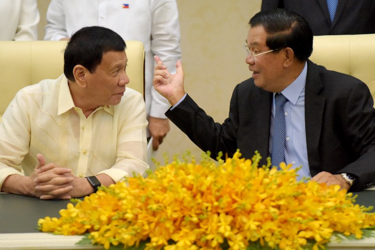 Cambodian Prime Minister Hun Sen (R) speaks to Philippines President Rodrigo Duterte (L) during a signing ceremony at the Peace Palace in Phnom Penh on December 14, 2016. / AFP PHOTO / TANG CHHIN SOTHY
