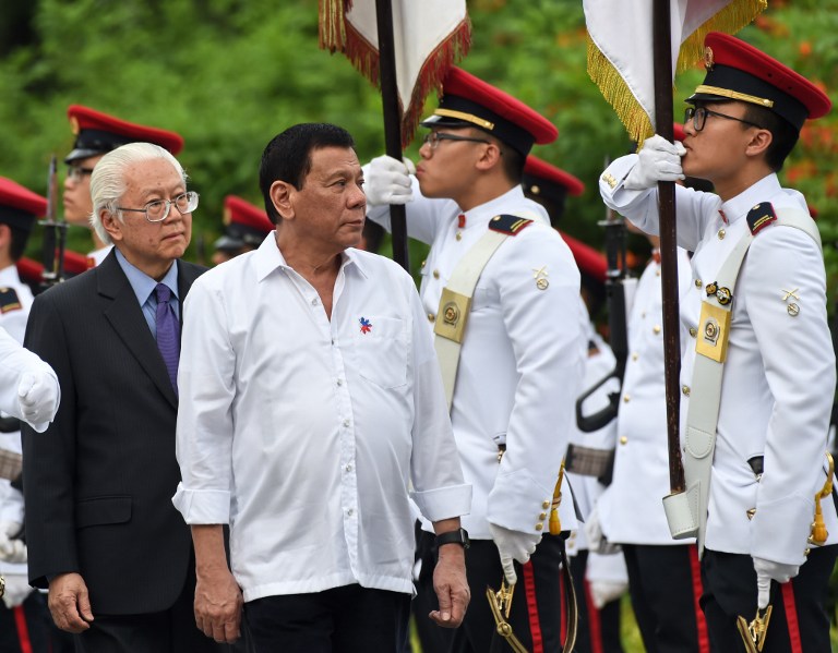 Philippines President Rodrigo Duterte (2nd L) and Singapore's President Tony Tan (L) inspect the guard of honour during a welcoming ceremony at Istana presidential palace in Singapore on December 15, 2016. Duterte is on a two-day state visit in Singapore. / AFP PHOTO / ROSLAN RAHMAN