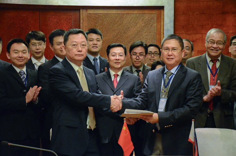 This handout photo taken and released by the Philippine coast Guard-Public Information Office (PCG-PIO) on December 16, 2016 shows Philippine coast guard commander Commodore Joel Garcia (R) shaking hands with Chinese coast guard deputy director general Yun De (L) at the end of their meeting in Manila. The Chinese and Philippine coast guards met for the first time on Friday and agreed to move forward on maritime cooperation, officials said, as relations between Beijing and Manila warm under Philippine President Rodrigo Duterte. / AFP PHOTO / PCG / HO / RESTRICTED TO EDITORIAL USE - MANDATORY CREDIT "AFP PHOTO / PHILIPPINE COAST GUARD" - NO MARKETING NO ADVERTISING CAMPAIGNS - DISTRIBUTED AS A SERVICE TO CLIENTS