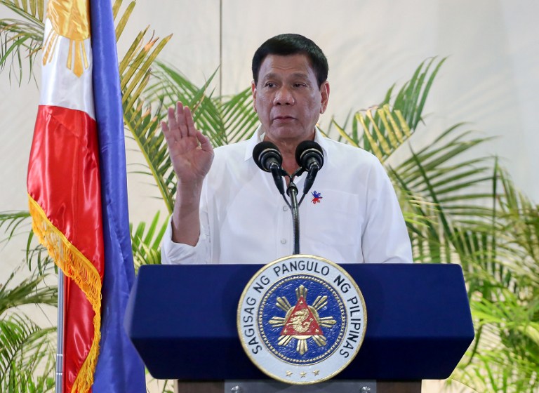 Philippine President Rodrigo Duterte gestures during a press conference shortly after arriving from Singapore at Davao international airport in southern island of Mindanao early December 17, 2016. Duterte boasted again on December 16, he had killed criminals, as he vowed no let up in his war on drugs that has already claimed thousands of lives. But after flying home from Singapore to his southern hometown of Davao, Duterte outlined how, as city mayor in 1988, he and two policemen had shot dead three men who had collected a ransom payment for a kidnapped local woman. / AFP PHOTO / MANMAN DEJETO