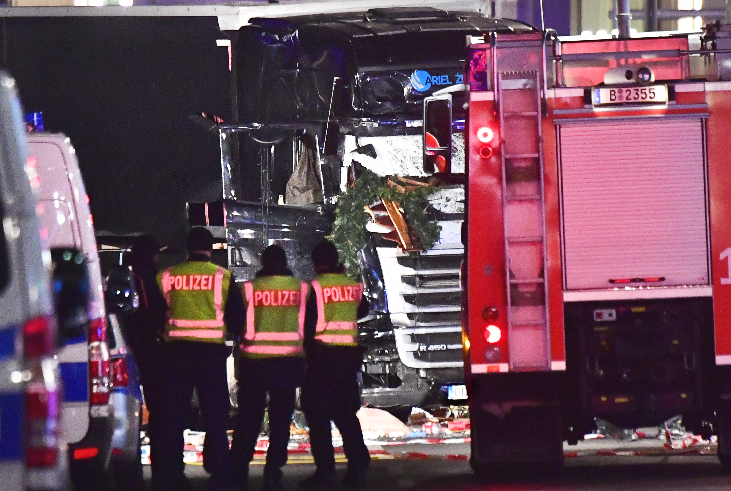 Police officers inspect the truck that crashed into a christmas market at Gedächniskirche church in Berlin, on December 19, 2016 killing at least nine people and injuring at least 50 people. Ambulances and heavily armed officers rushed to the area after the driver drove up the pavement of the market in a square popular with tourists, in scenes reminiscent of the deadly truck attack in the French city of Nice in July. / AFP PHOTO / John MACDOUGALL