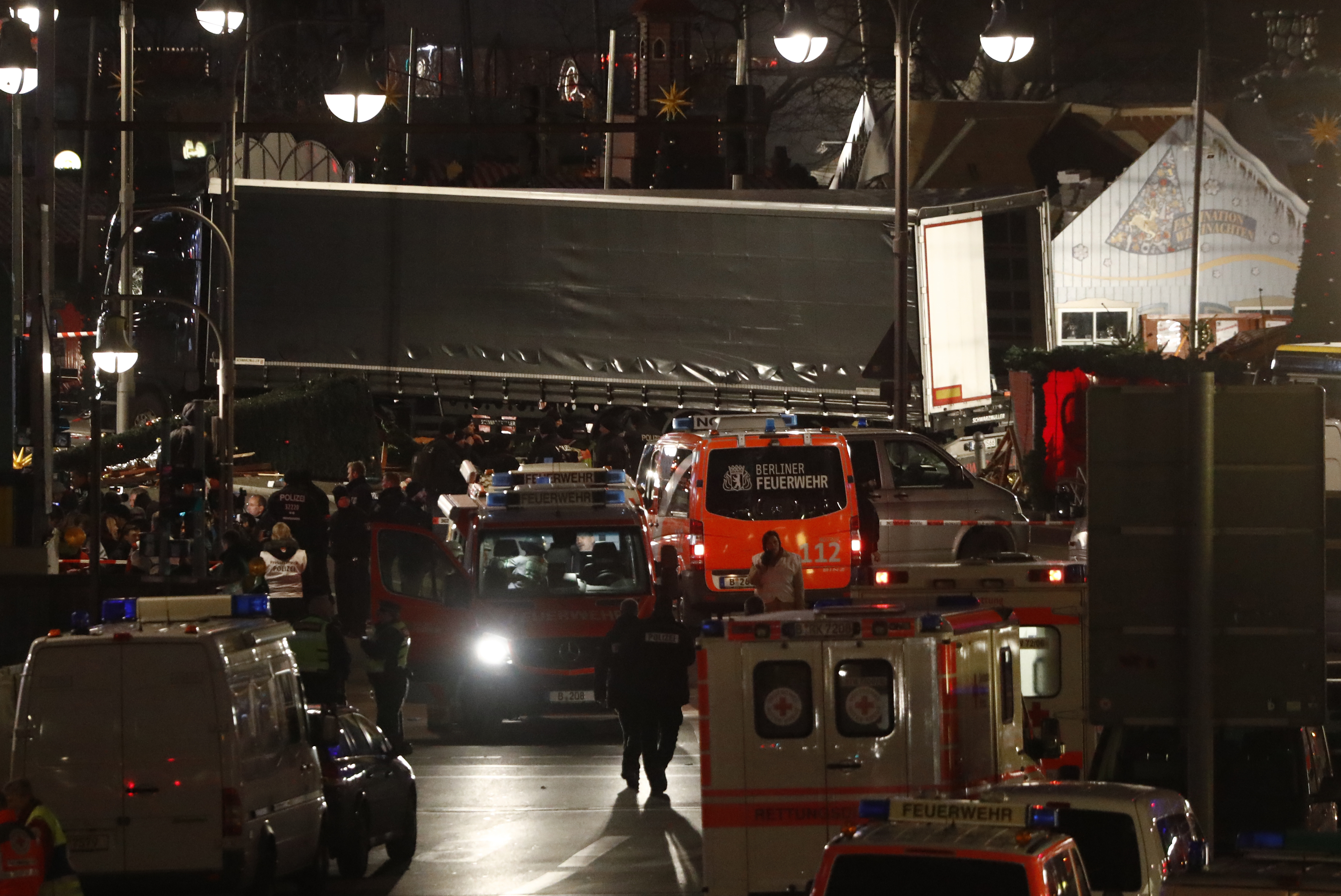 Ambulances stand next to a truck that speeded into a christmas market in Berlin, on December 19, 2016 killing nine persons and injuring at least 50 people. Ambulances and police rushed to the scene after the driver drove up the pavement of the market in a central square popular with tourists less than a week before Christmas, in a scene reminiscent of the deadly truck attack in Nice. / AFP PHOTO / Odd ANDERSEN