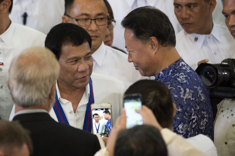 (FILES) This file picture taken on August 17, 2016 shows Philippine President Rodrigo Duterte (L) talking to Chinese Ambassador to the Philippines Zhao Jianhua during the 115th Police Service Anniversary at the Philippine National Police (PNP) headquarters in Manila. China has offered the Philippines guns and equipment worth $14 million to wage its war on drugs and combat terrorism, Manila's defence minister said on December 20, 2016, as ties improve under President Rodrigo Duterte. / AFP PHOTO / NOEL CELIS