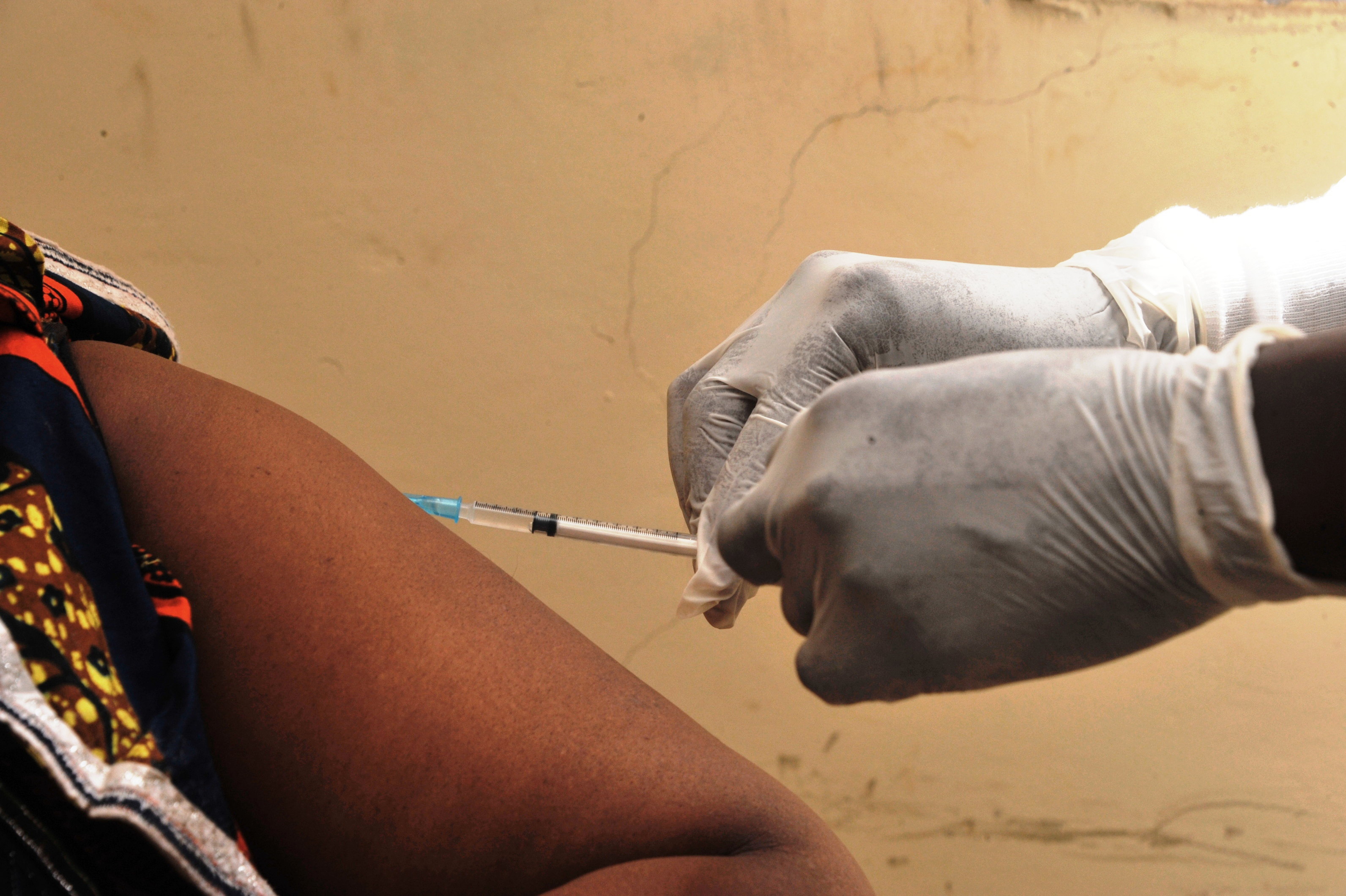 (FILES) This file photo taken on March 10, 2015 shows a woman getting vaccinated at a health center in Conakry during the first clinical trials of the VSV-EBOV vaccine against the Ebola virus.  An ebola vaccine tested in clinical trials is "up to 100 percent effective" in protecting against the deadly virus, the World Health Organization reported in a study published on December 22, 2016. Not one of the nearly 6,000 people in Guinea vaccinated last year after being exposed to ebola contracted the disease, which claimed more than 11,000 victims in west Africa during a 2013-2015 outbreak, researchers reported in The Lancet. / AFP PHOTO / Cellou BINANI