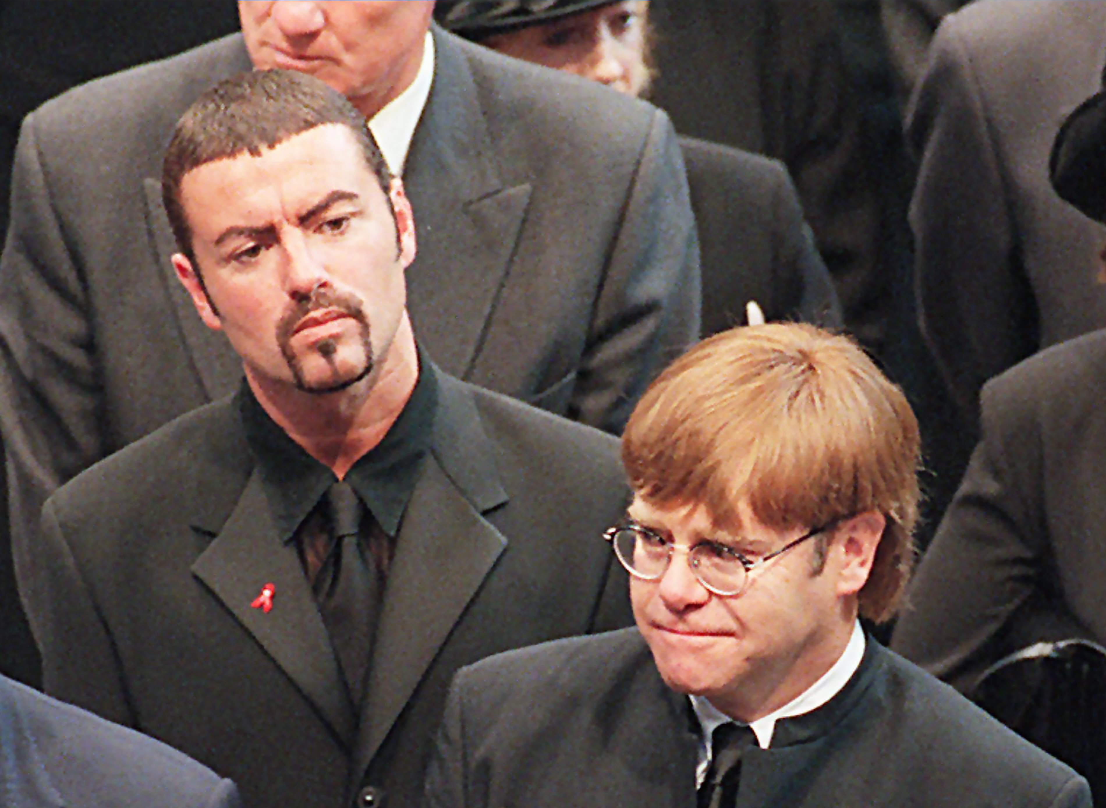 (FILES): This file photo taken on September 6, 1997 shows pop stars George Michael (L) and Elton John (R) leaving Westminster Abbey following the funeral service of Diana, Princess of Wales. British pop singer George Michael, who rose to fame with the band Wham! and sold more than 100 million albums in his career, has died aged 53, his publicist said on Sunday, December 25, 2016. / AFP PHOTO / AFP POOL / JOHNNY EGGITT