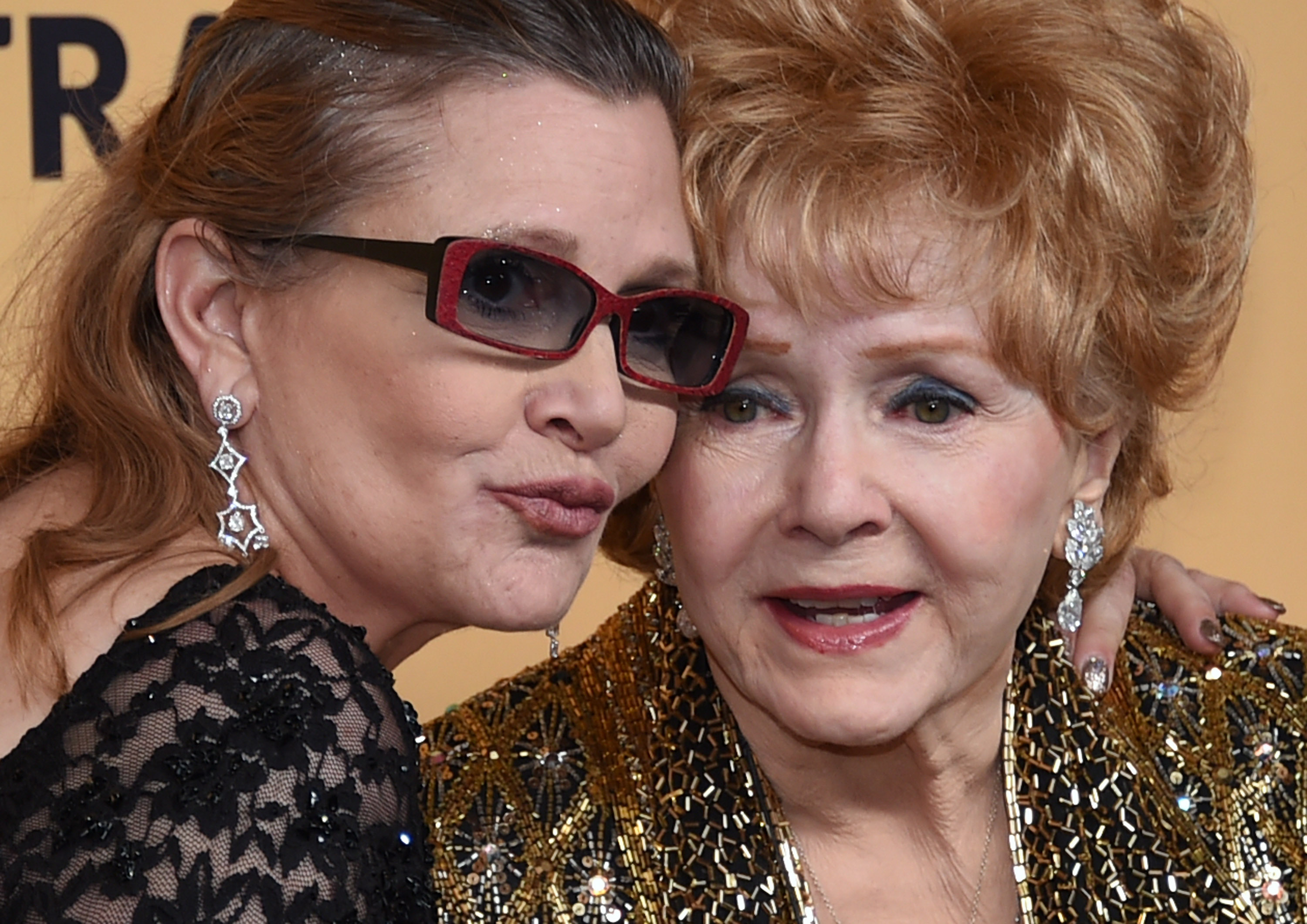 (FILES) This file photo taken on January 24, 2015 shows Debbie Reynolds (R), recipient of the Screen Actors Guild Life Achievement Award, and her daughter Carrie Fisher posing in the press room during the 21st Annual Screen Actors Guild Awards at The Shrine Auditorium in Los Angeles, California. Film legend Debbie Reynolds died on December 28, 2016 after suffering a stroke, a day after the death of her movie star daughter Carrie Fisher, US media reported. / AFP PHOTO / GETTY IMAGES NORTH AMERICA / Ethan Miller