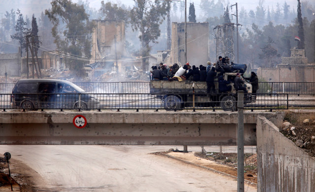 Evacuees from rebel-held eastern Aleppo ride on pick-up trucks along the government-held area of al-Ramousah bridge,  Syria December 16, 2016. REUTERS/Omar Sanadiki