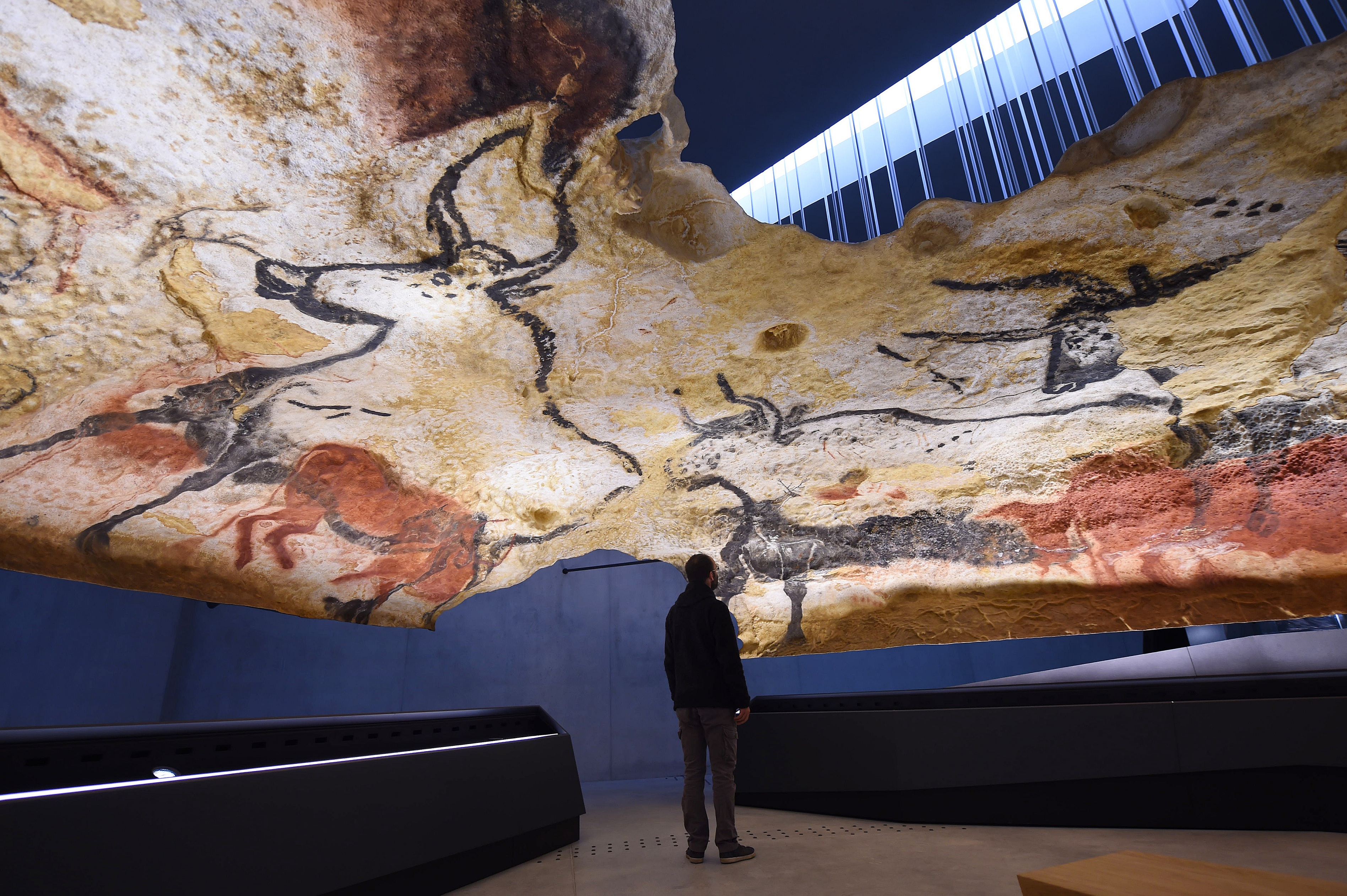 TO GO WITH AFP STORY BY JORDANE BERTRAND A person visits on November 28, 2016 a true-to-life replica of the renowned Lascaux's Stone Age cave with its Paleolithic paintings, in Montignac, southwestern France.  The cave of Lascaux is one of the largest decorated caves of the Paleolithic. The age of the paintings and engravings is estimated between about 18.000 and 17.000 years. Known as Lascaux 4, the first full replica of the Lascaux cave, reproduced identically by the Atelier des Fac-Similes du Perigord for a 66-million euros cost, before being mounted in the International Centre of the parietal art of Montignac-Lascaux, will opened on December 10, 2016.  / AFP PHOTO / MEHDI FEDOUACH